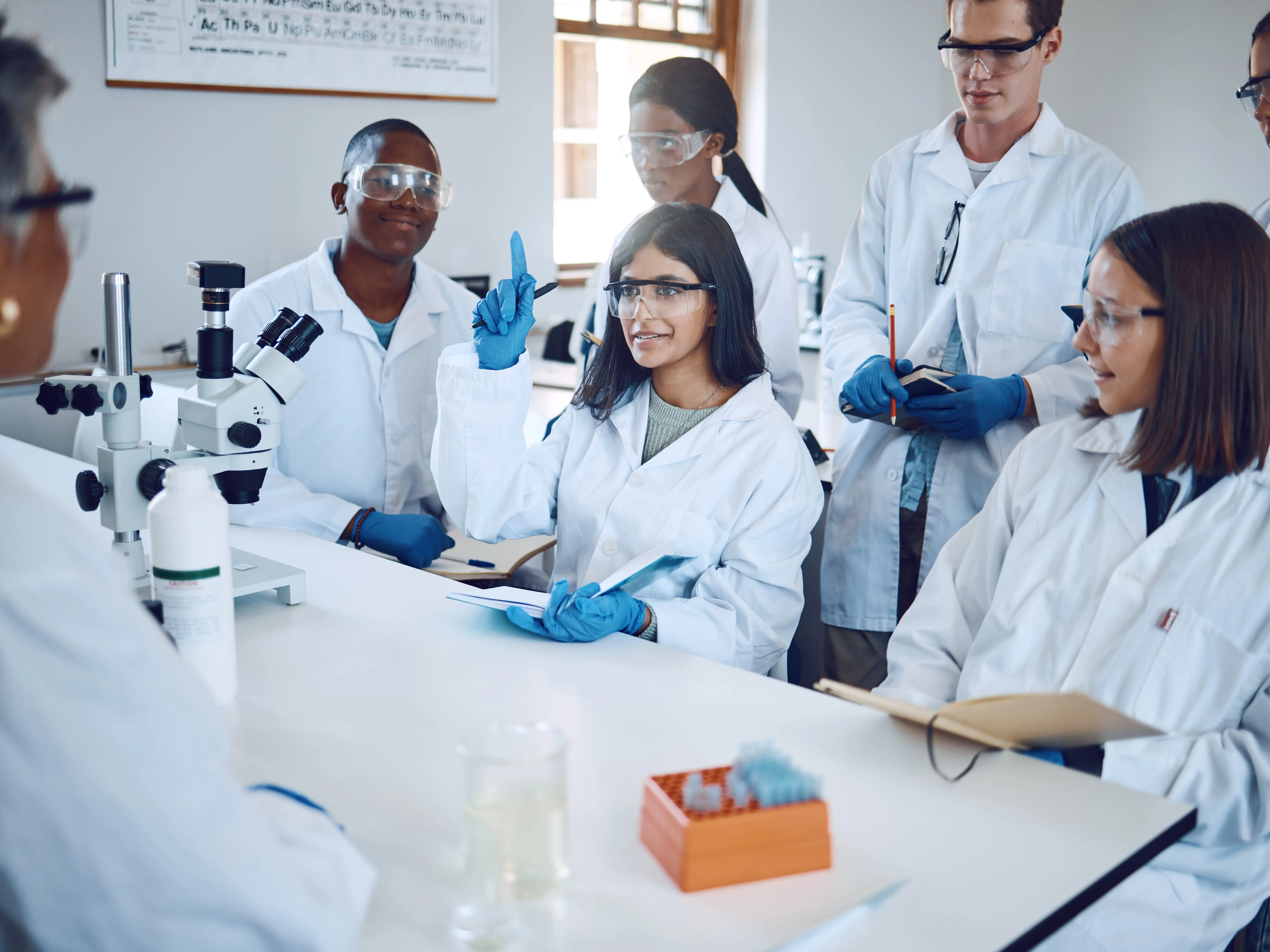 Students, research and girl question in laboratory, class and studying healthcare. Scientist, young researchers or lecture for medical innovation, scientific methods and woman raise hand or education stock photo
