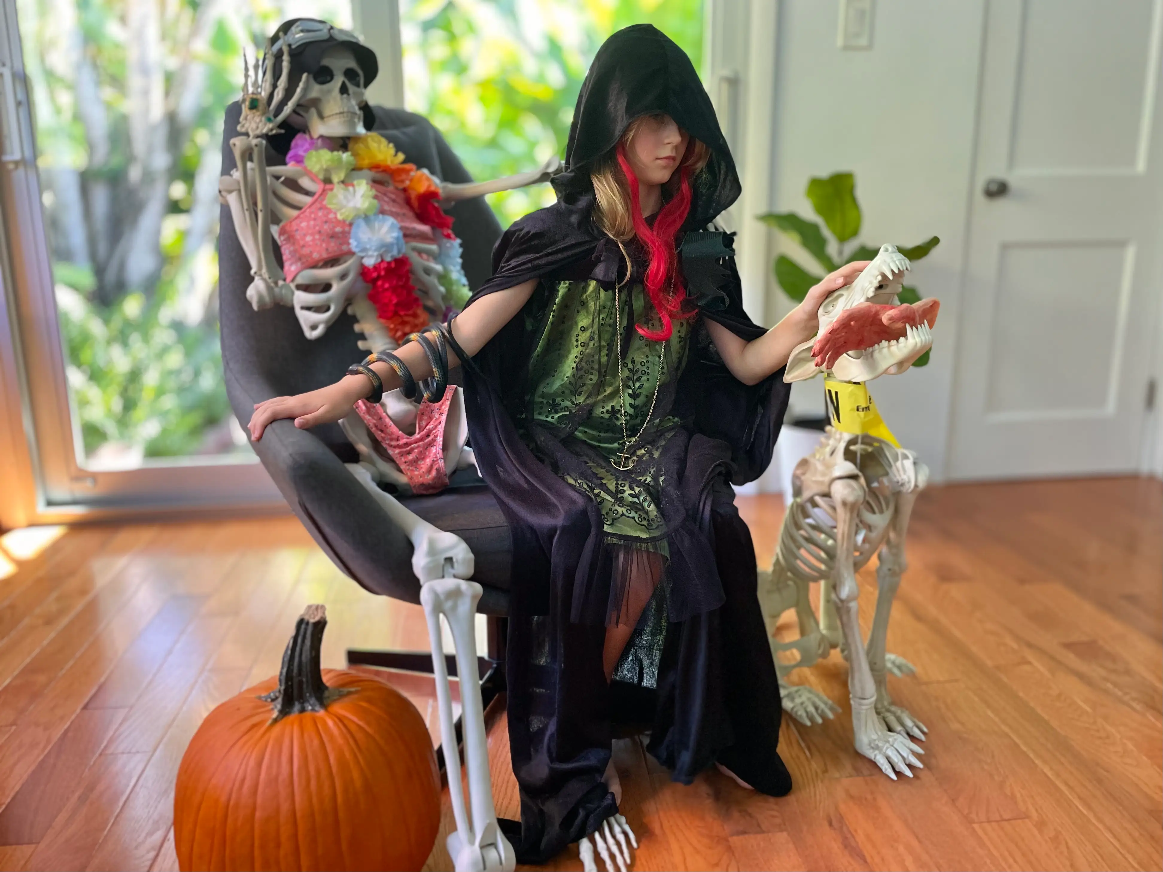 the author's daugter wearing a halloween costume sitting with halloween decorations