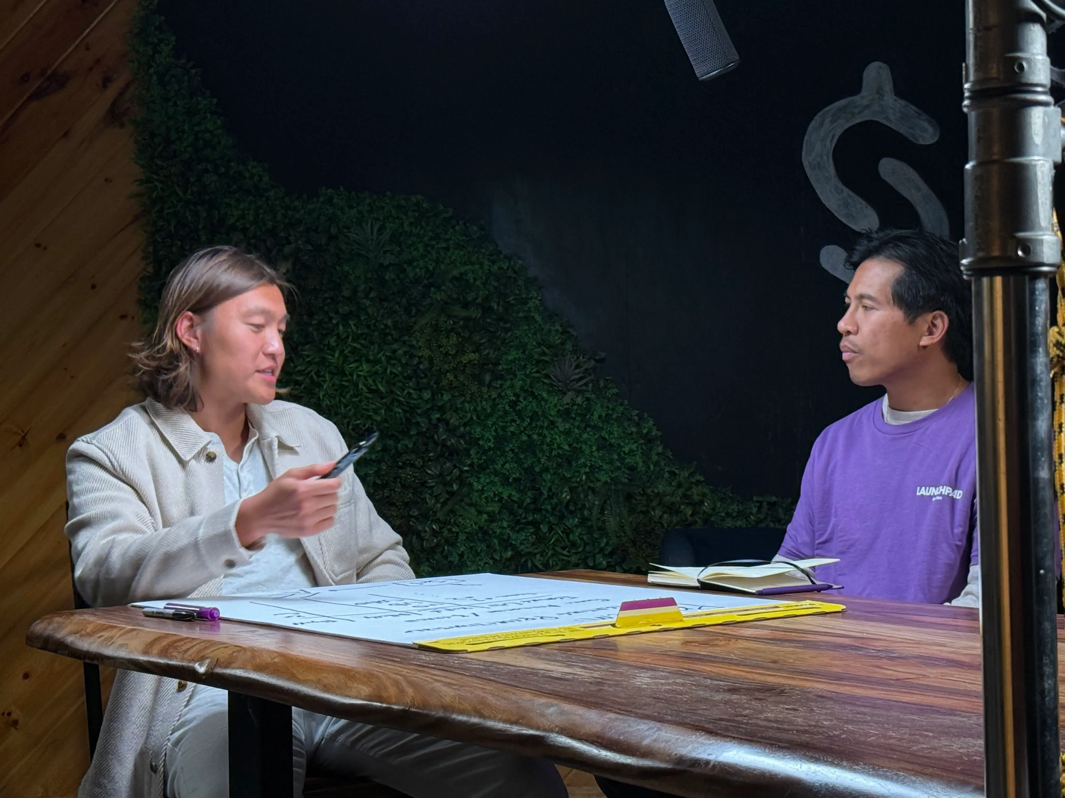 Stan cofounder John Hu explains marketing to Rey Mendoza, a 42-year-old Canadian with a startup for production management.