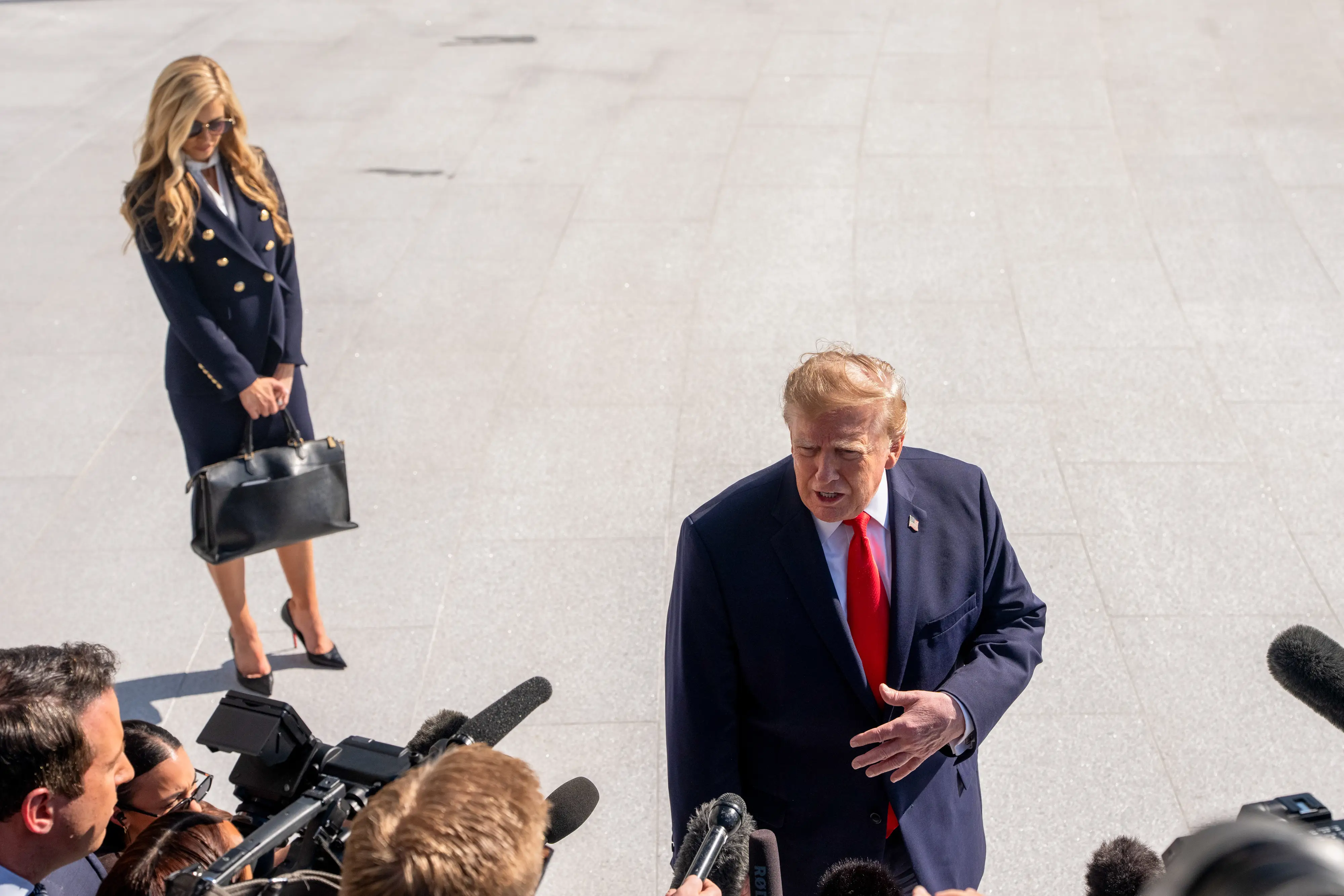 Katie Zacharia stands by President Trump as he speaks with reporters.
