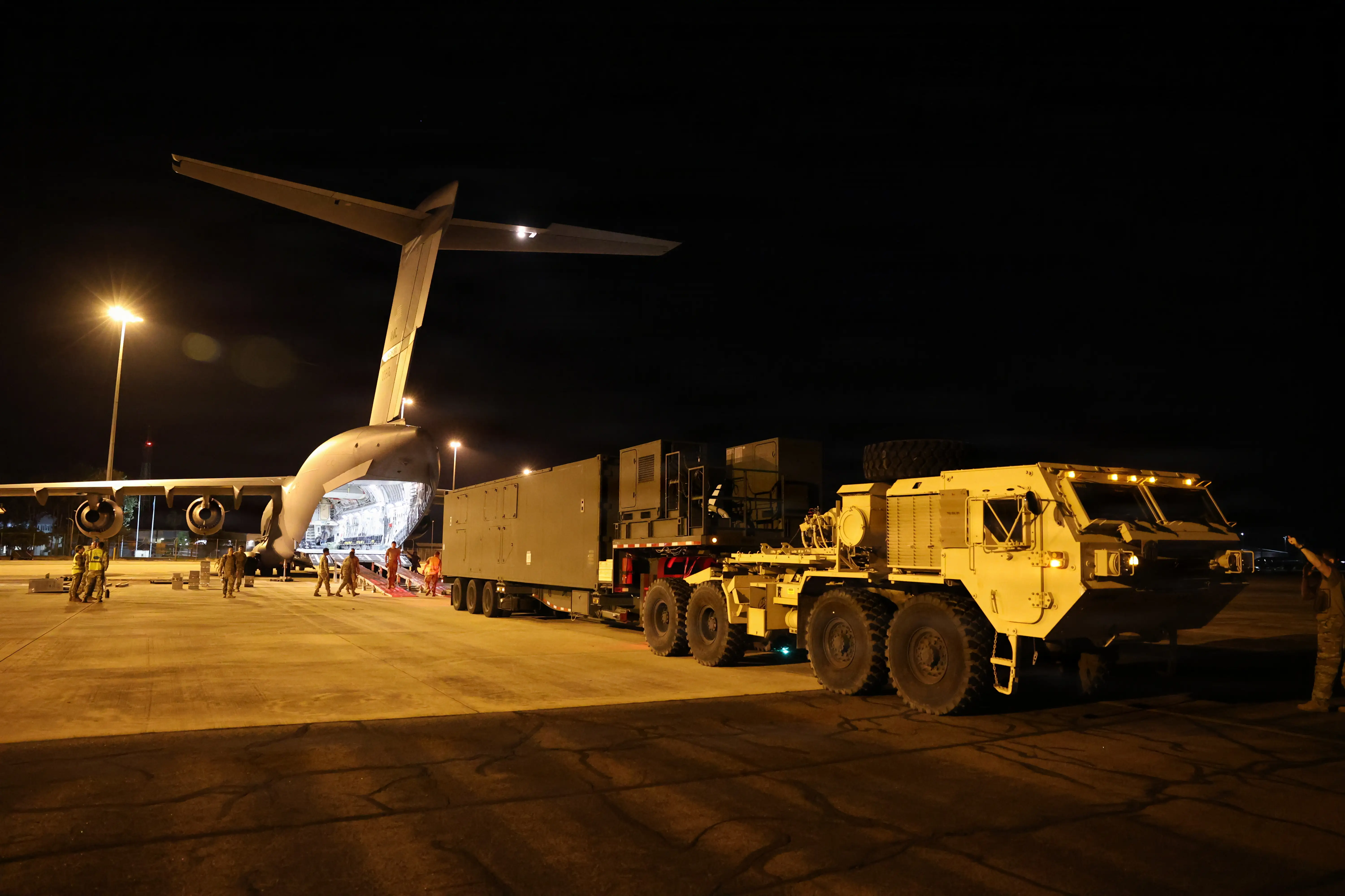 The Typhon missile system seen driving with a truck after pulling off a C-17 Globemaster III.