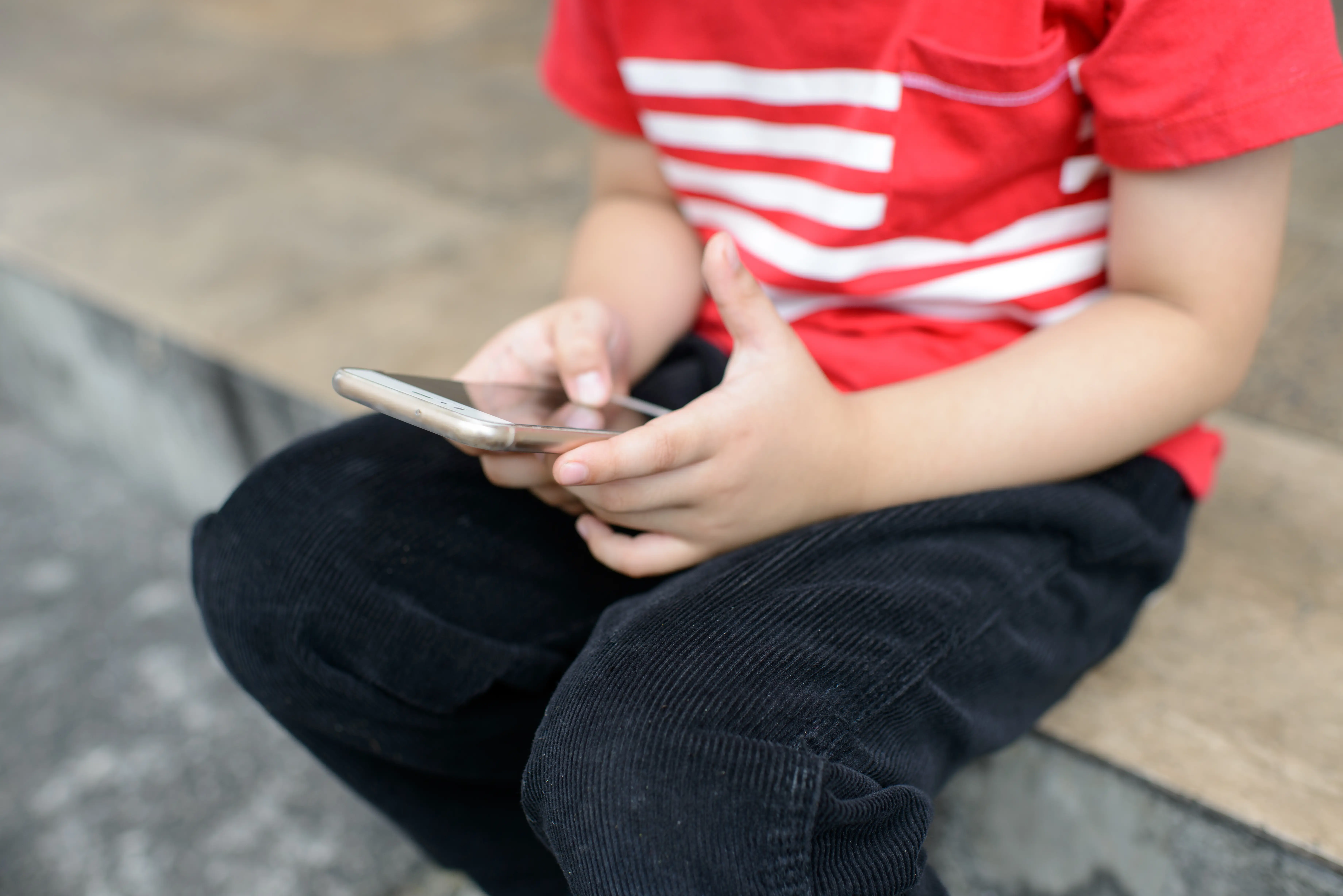 young boy holding smartphone