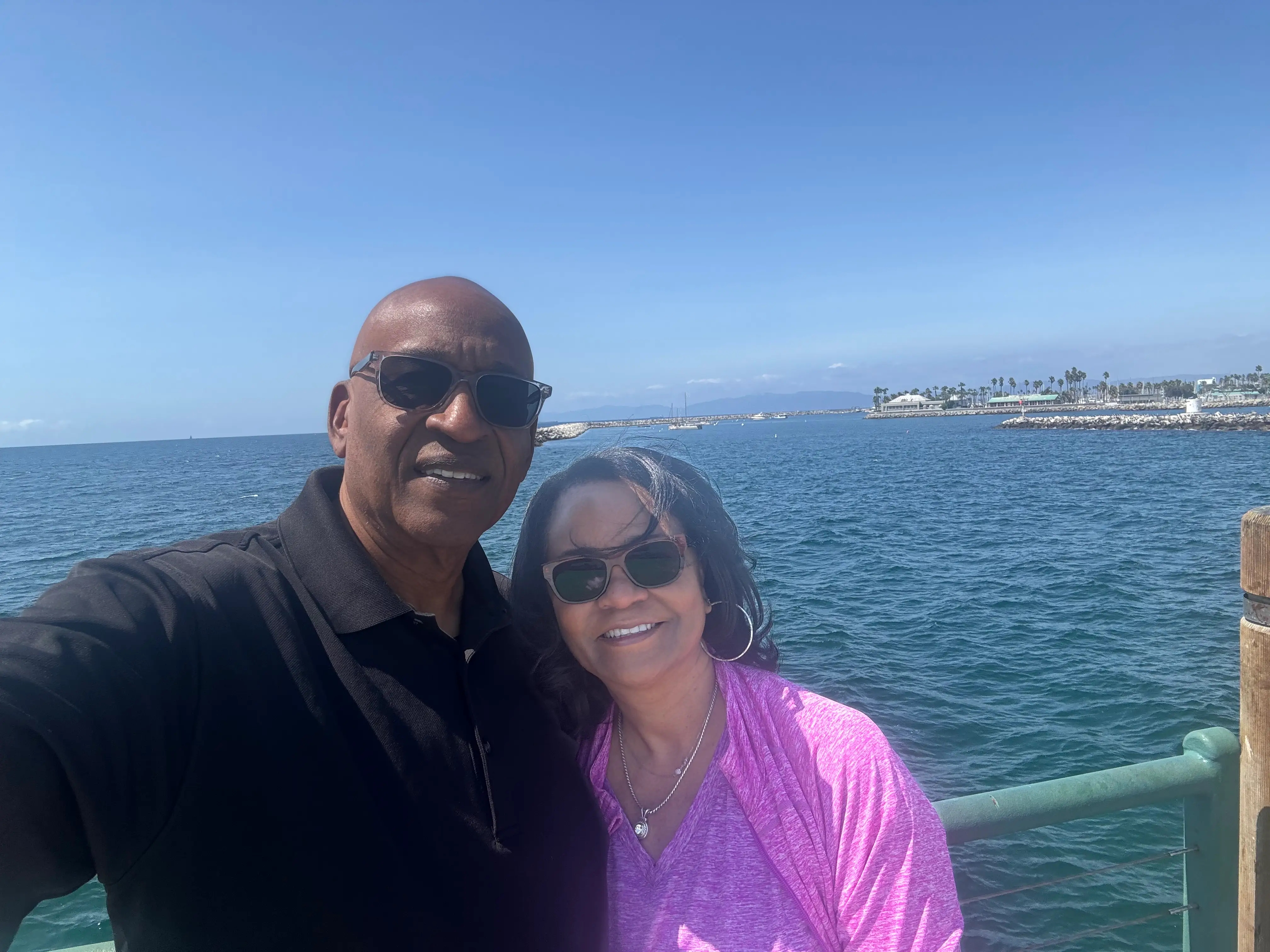 A man and a woman standing in front of a waterway.