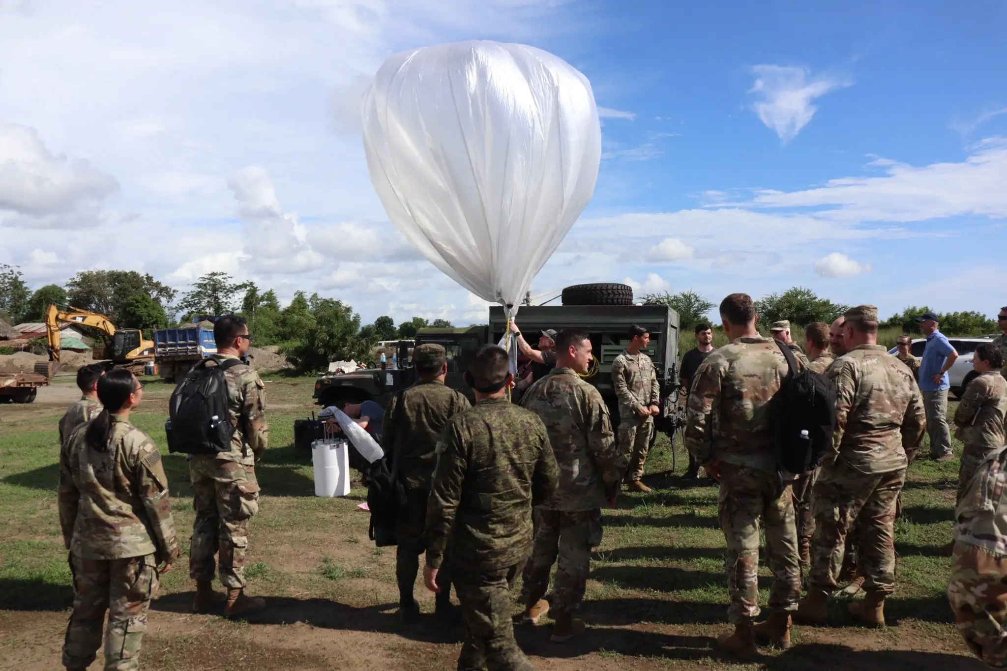A surveillance balloon inflating with the US army and partners.