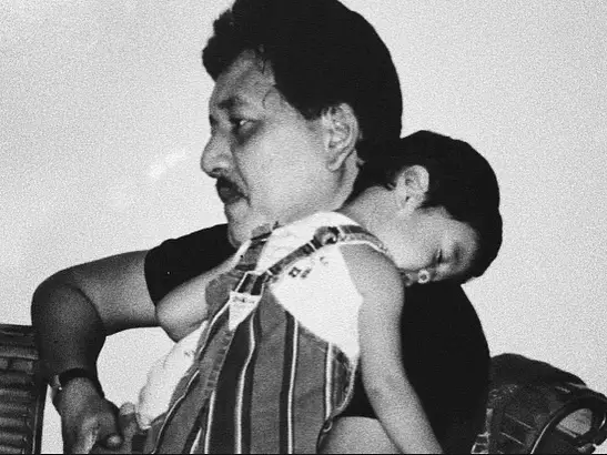 A black and whitei mage of the author as a baby in the arms of his late dad.