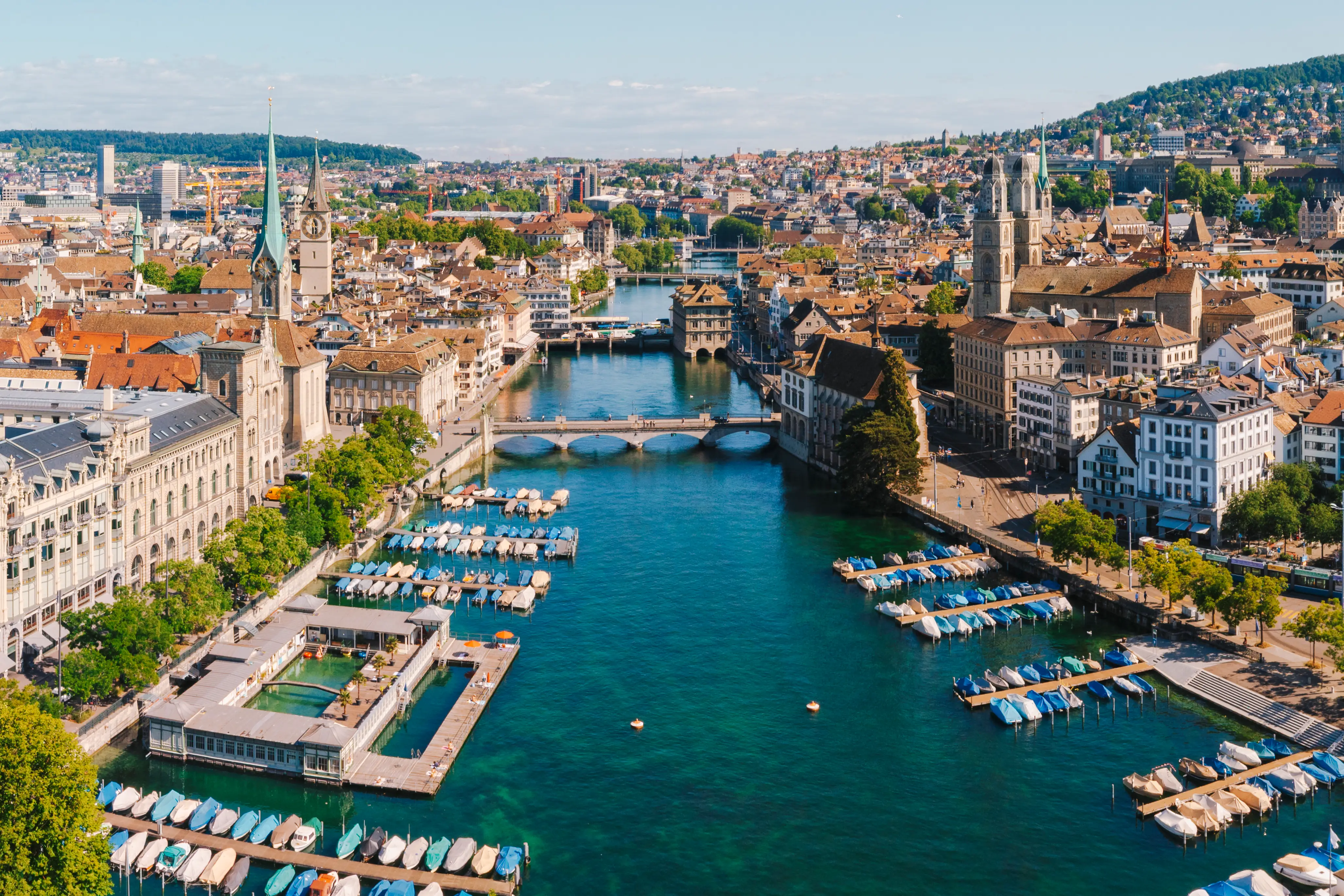 Aerial view of Zürich old town with the Limmat River, bridges, church towers, and boat docks.