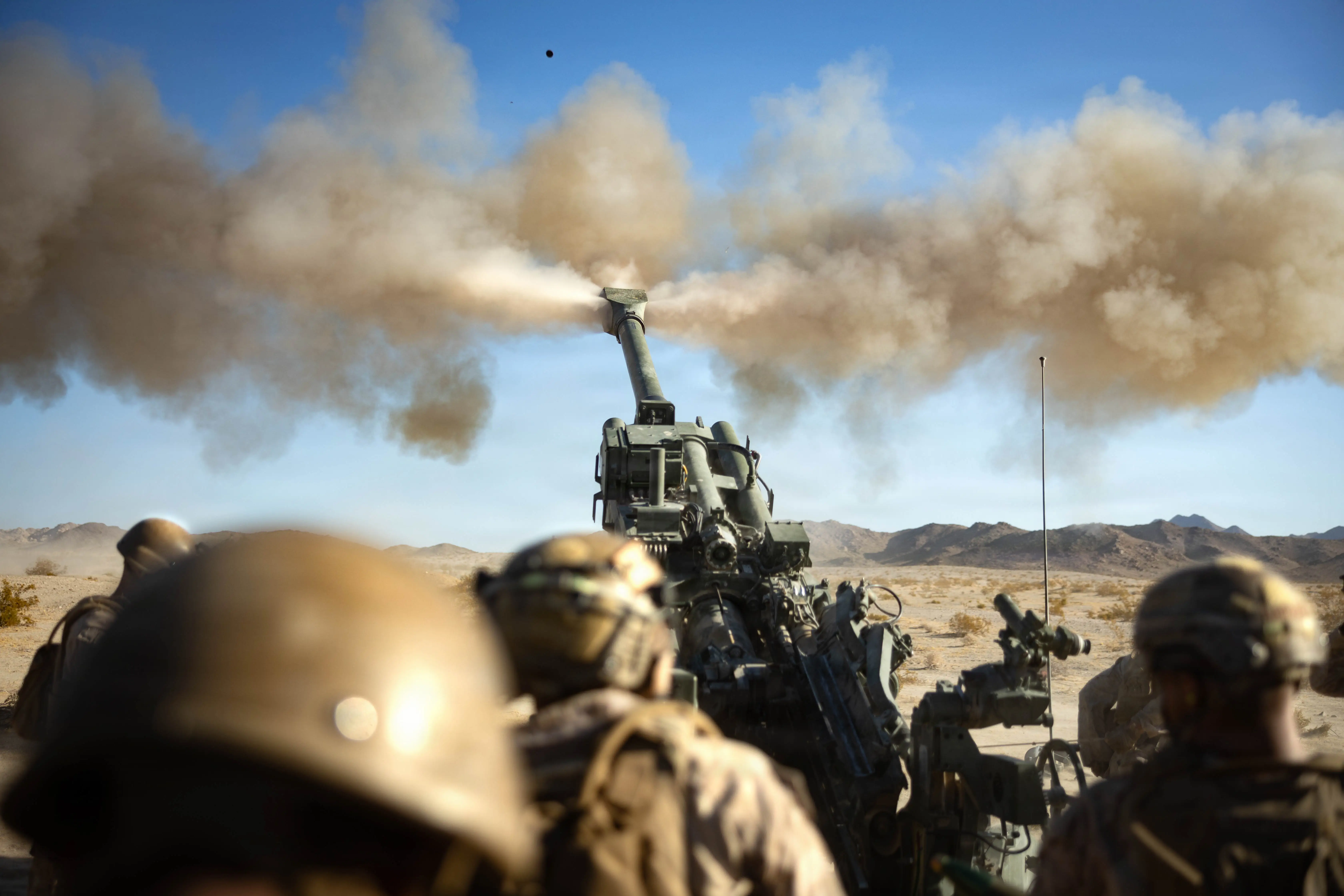 US Marines fire a 155mm round from an M777A2 Howitzer.