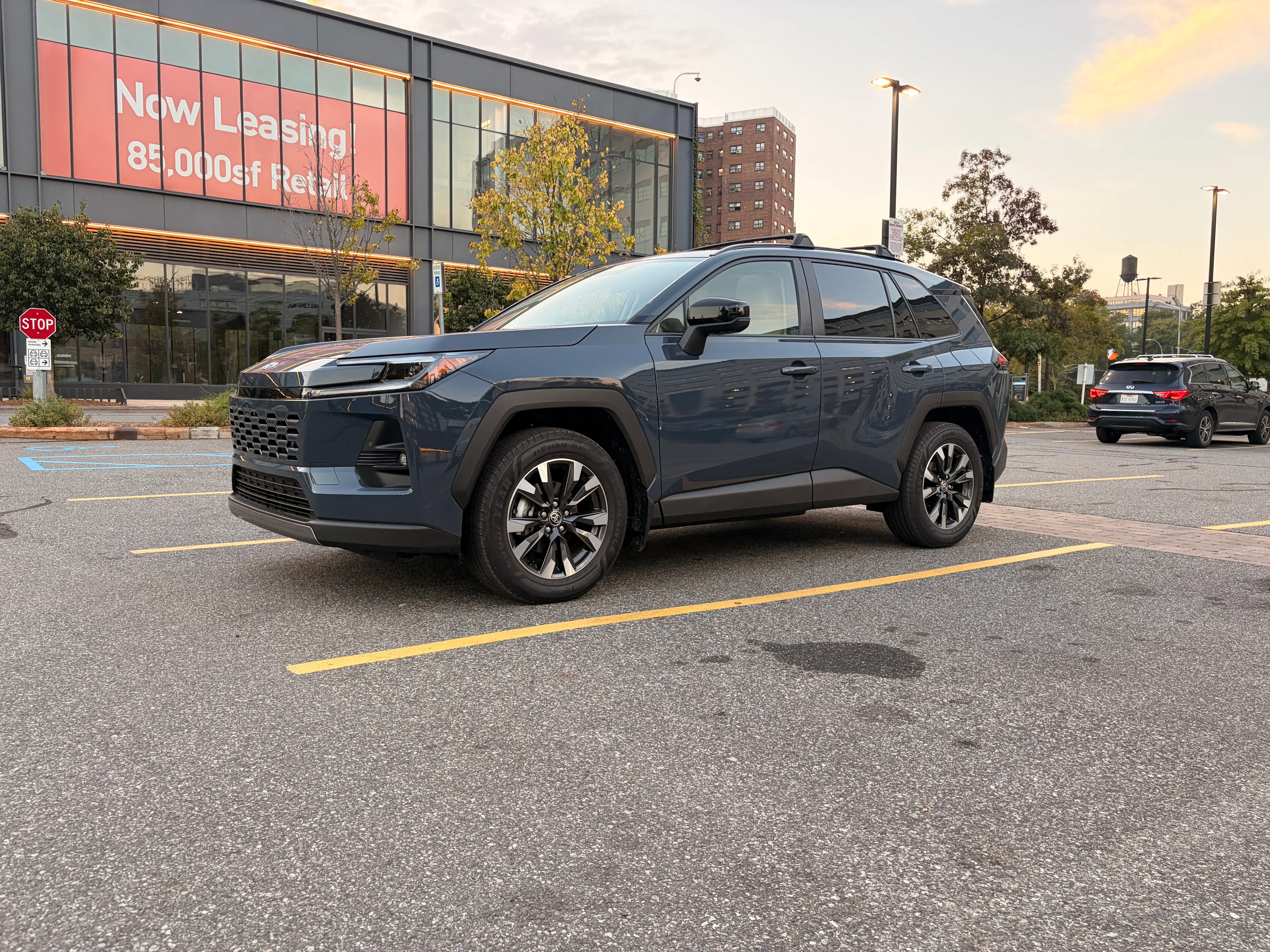 A blue 2026 Toyota RAV4 Limited is parked in a grocery store lot.