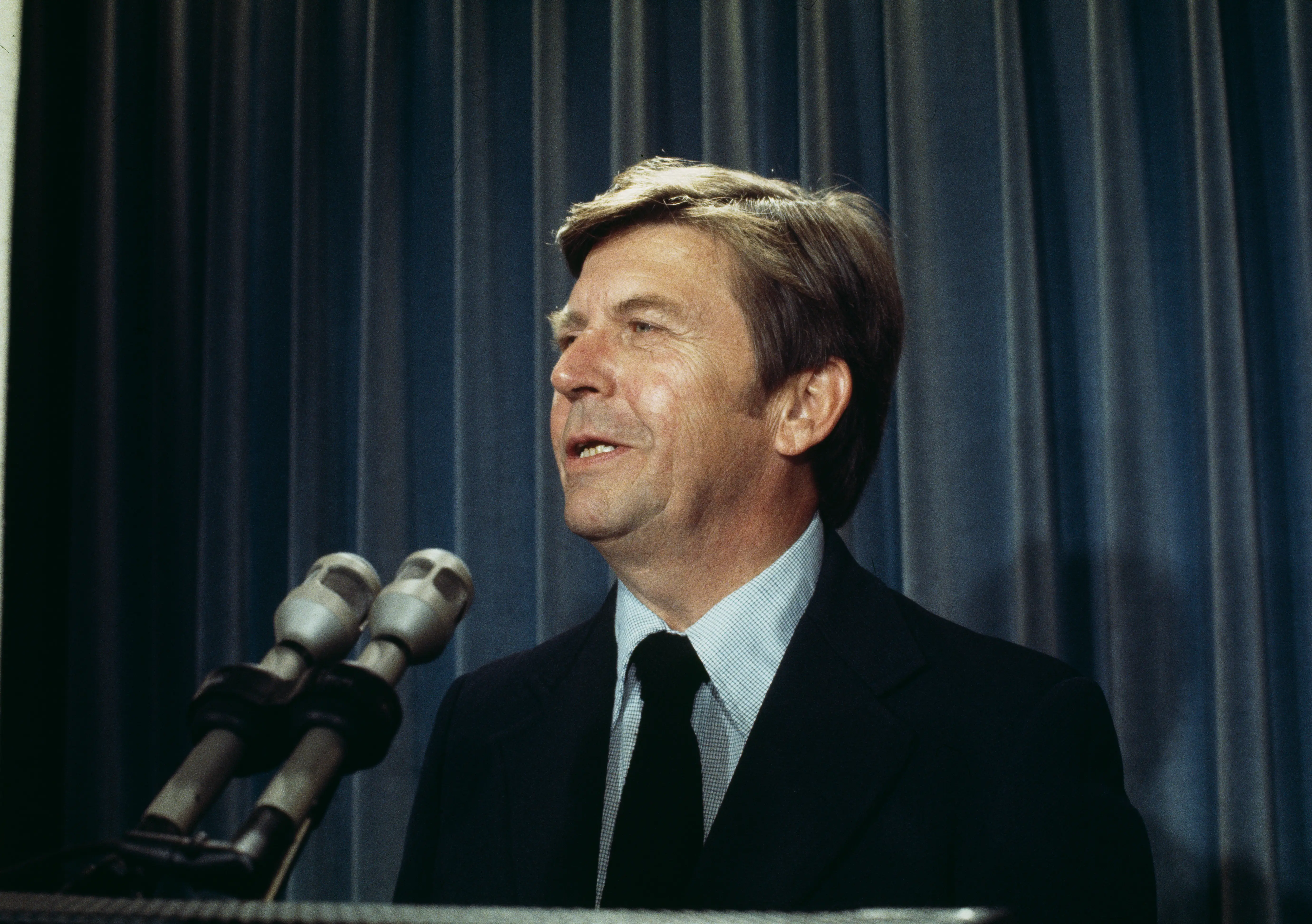 A man in a suit speaks.