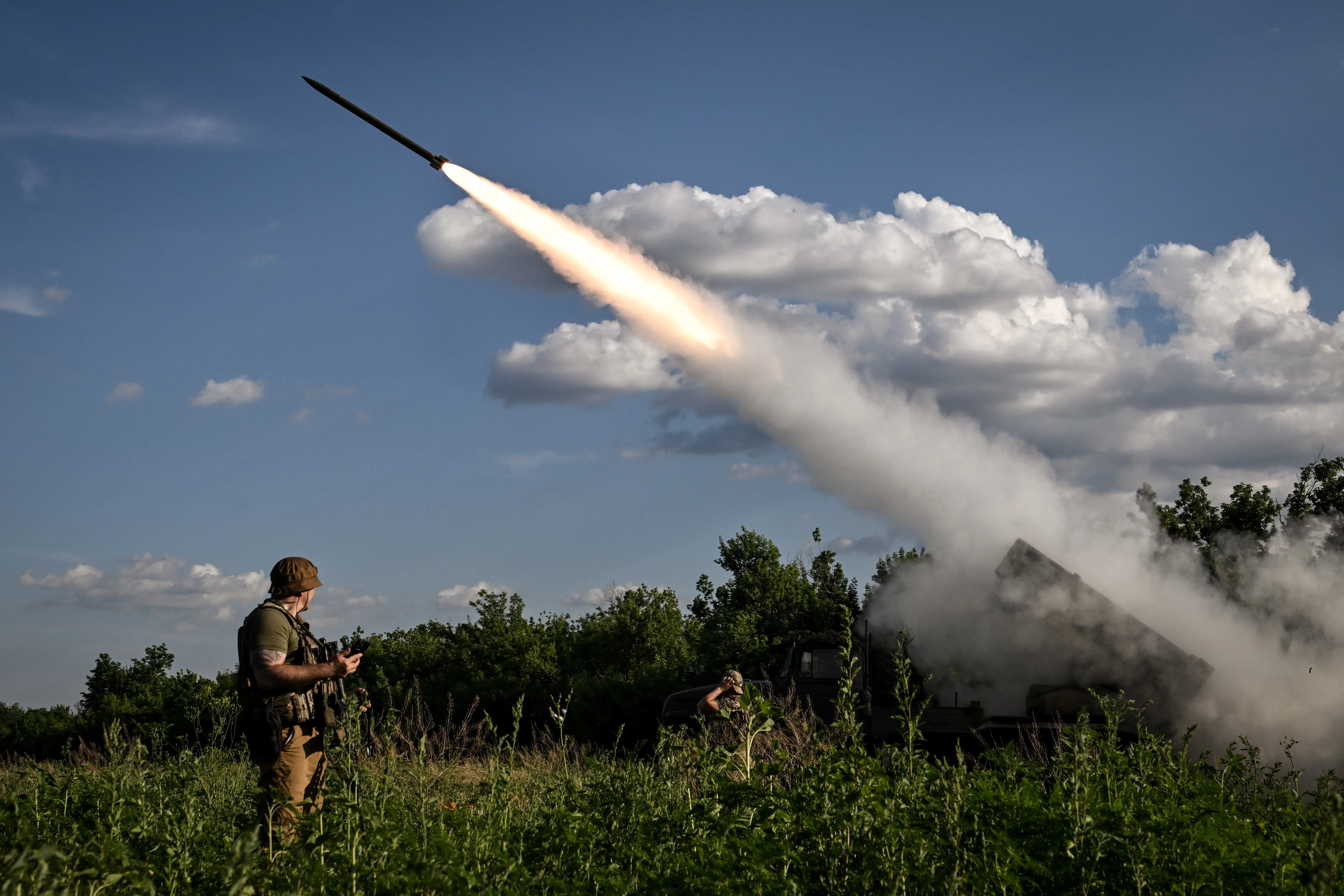 A soldier watches as a rocket fires form an MLRS.