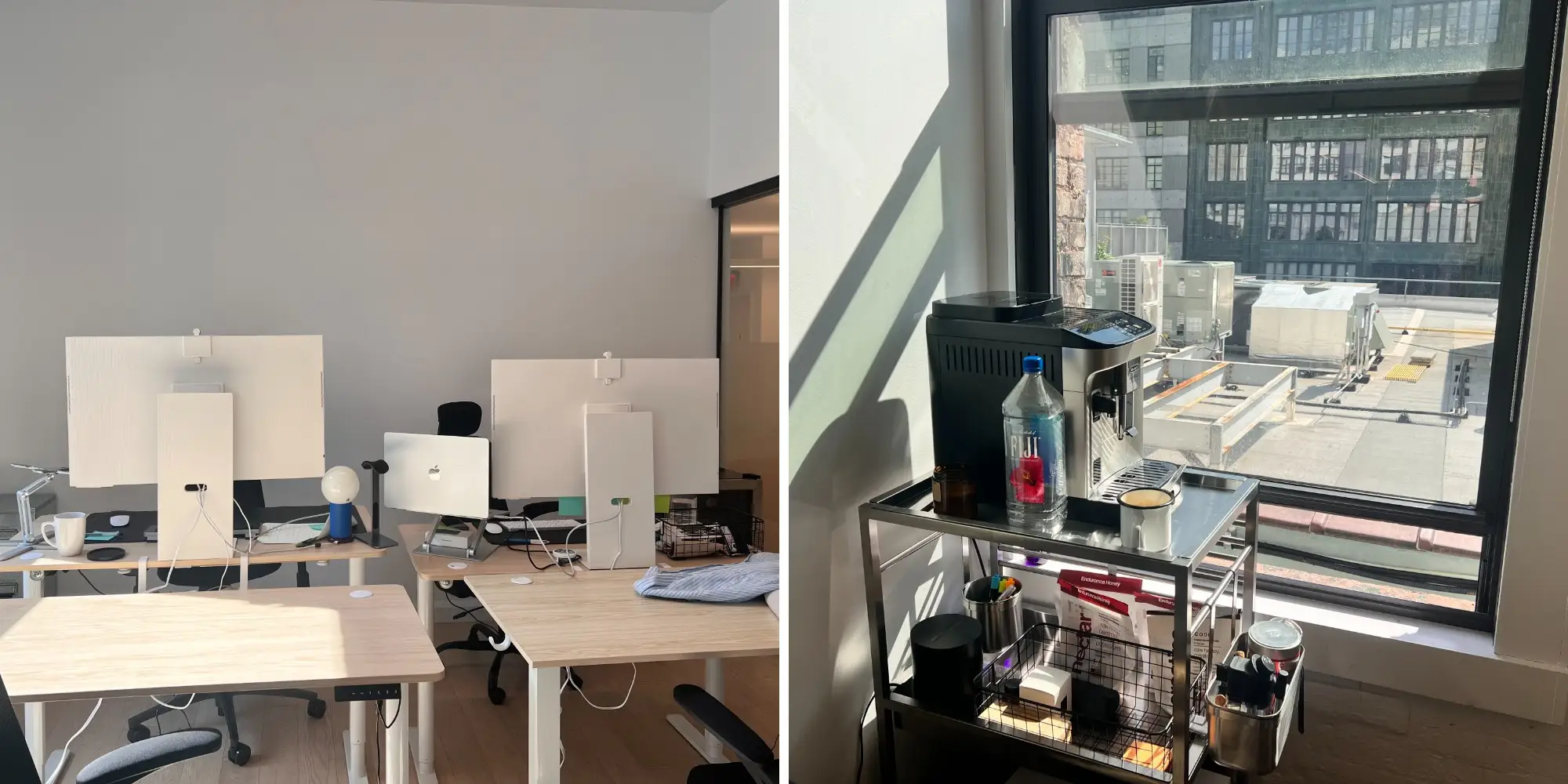 Modern office workspace with standing desks, Apple monitors, and a coffee cart beside a sunlit window.