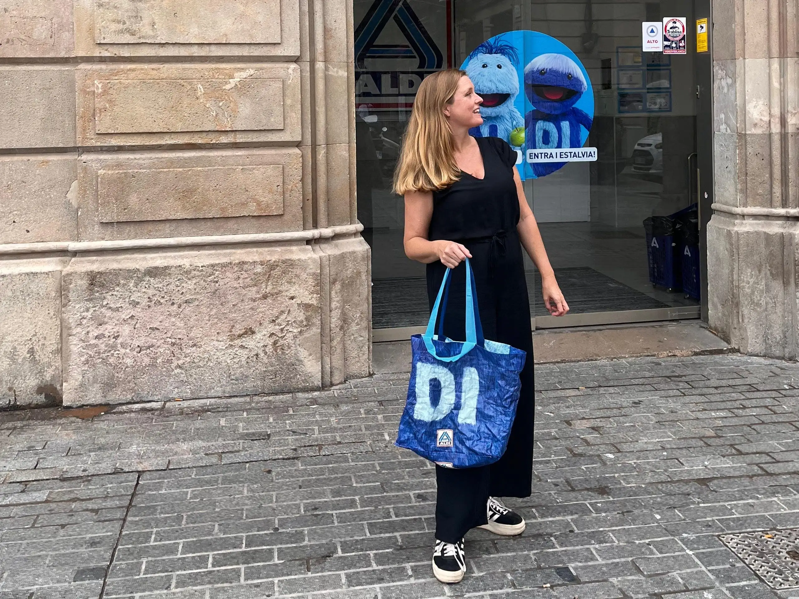 Woman with grocery bag in front of Aldi in Spain