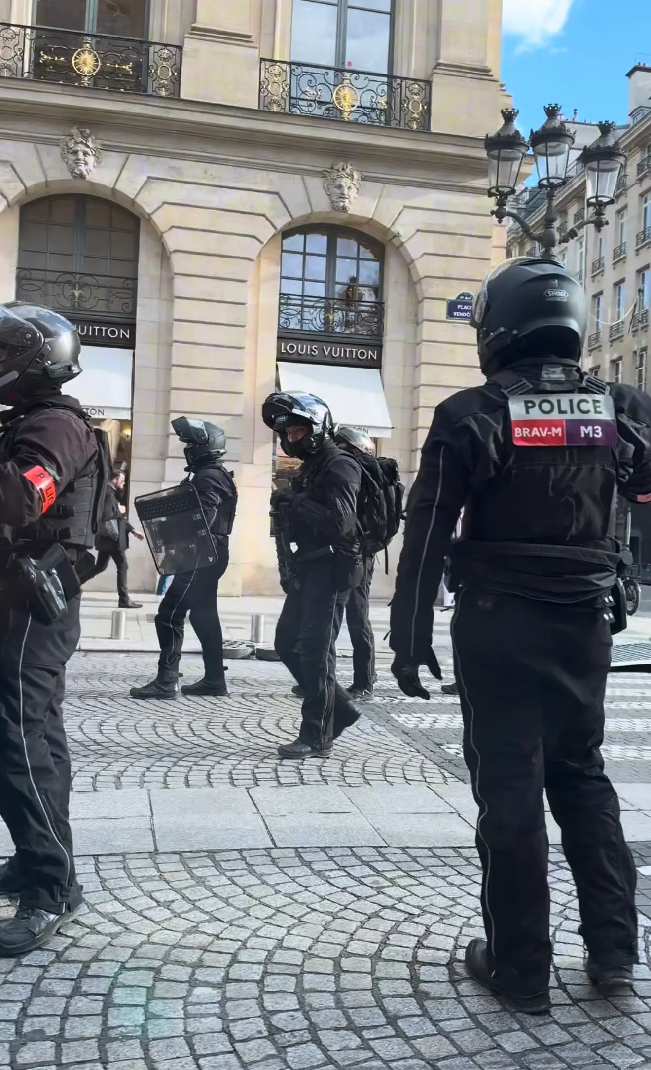 Riot police stand outside a Louis Vuitton store in central Paris during the unrest.