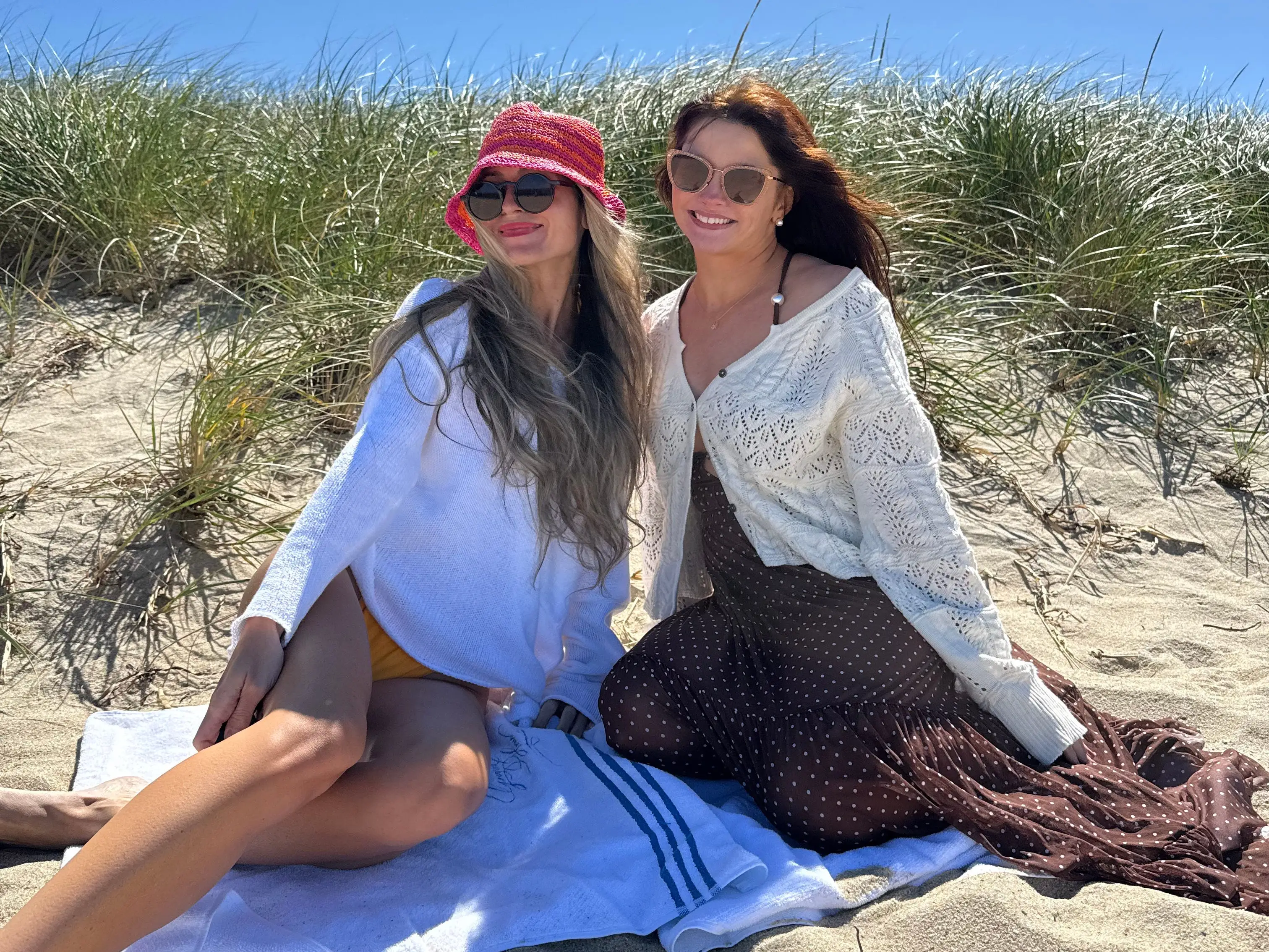 Two women smiling on blanket at beach in Nantucket