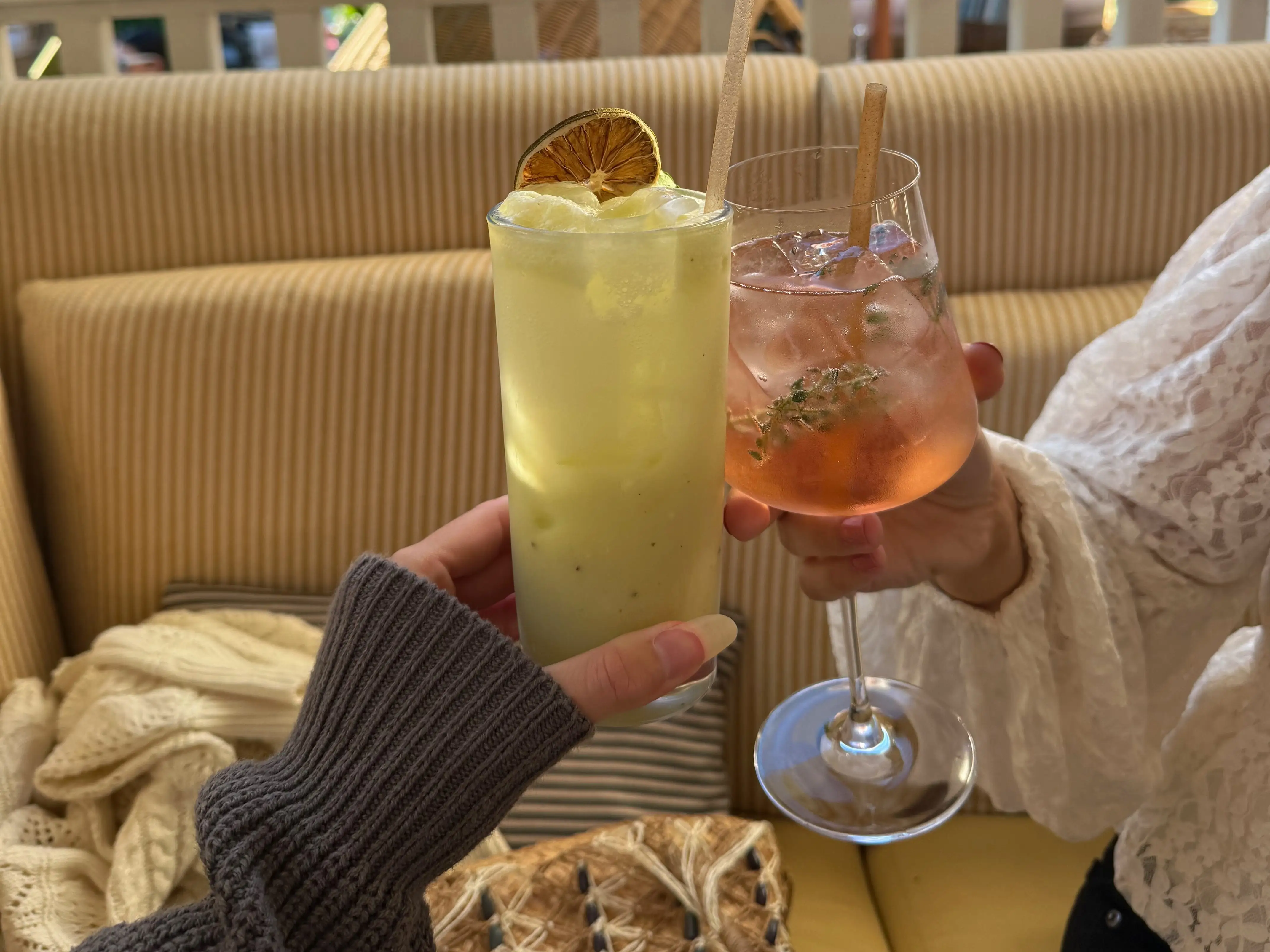 Two women cheers-ing cocktails