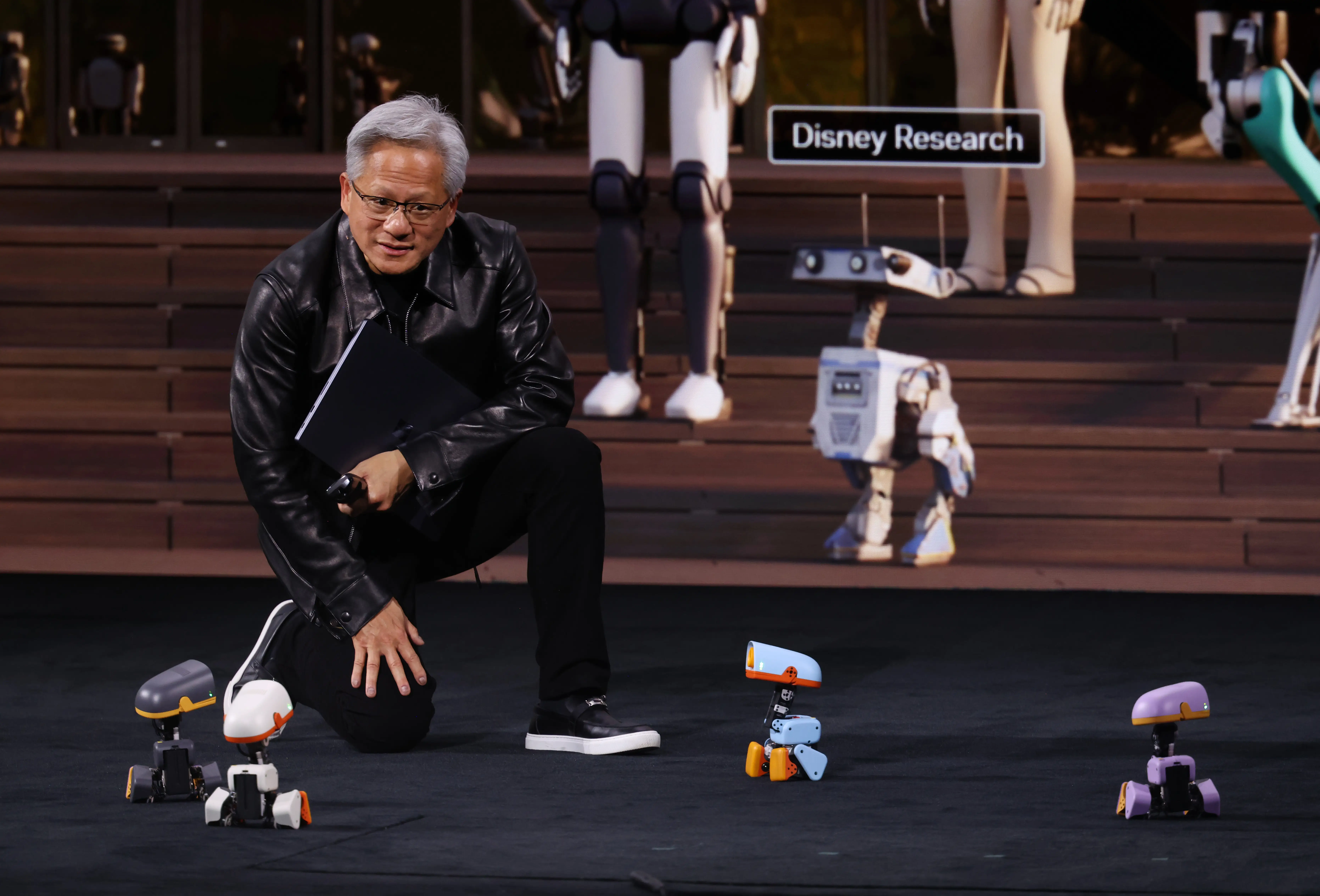 Jensen Huang, CEO of NVIDIA, speaks to Micro Duck robots during his keynote address at the Berlin GPU Technology Conference in Berlin.