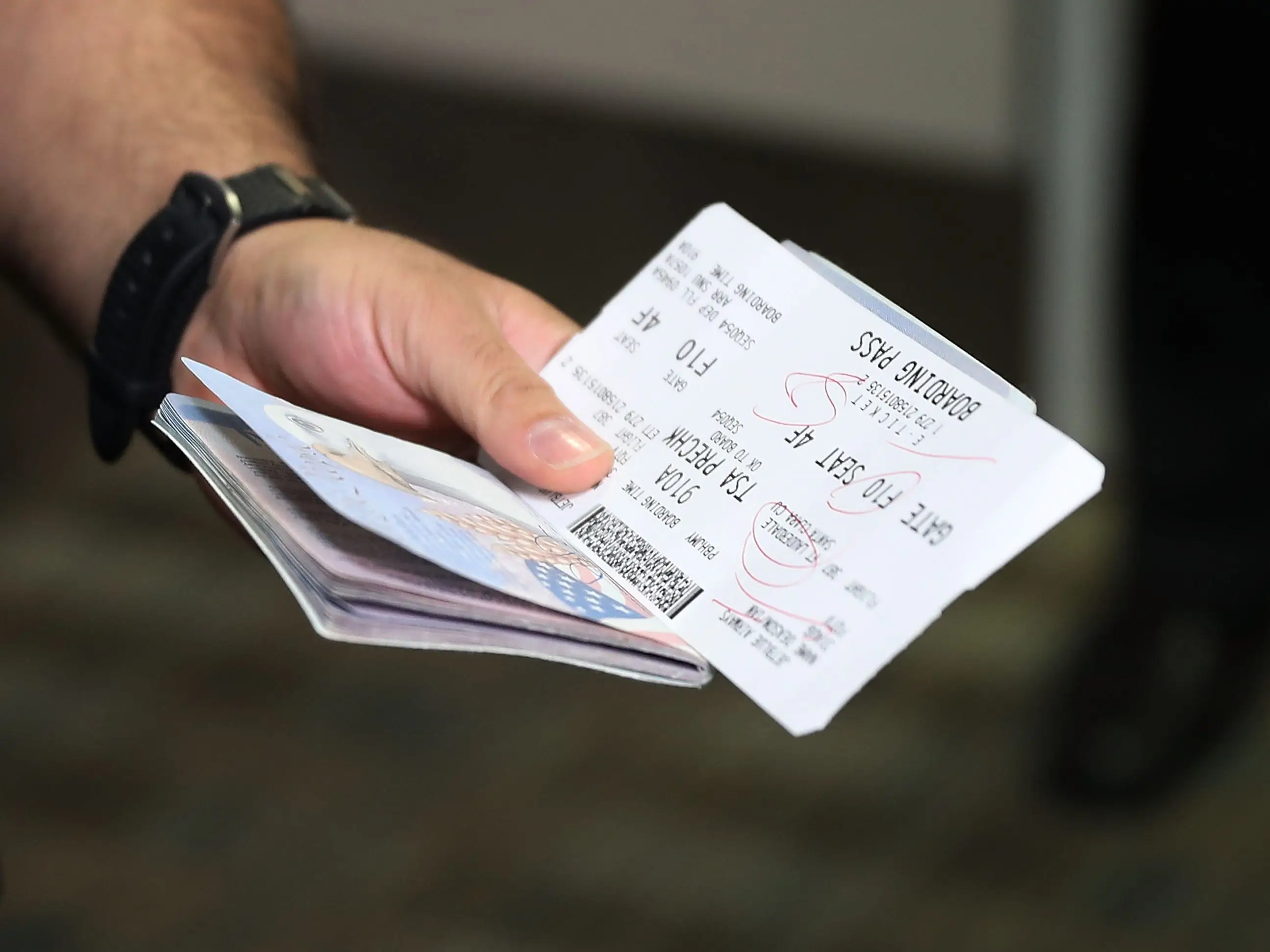 A passenger holds his passport and ticket at the Fort Lauderdale-Hollywood International Airport