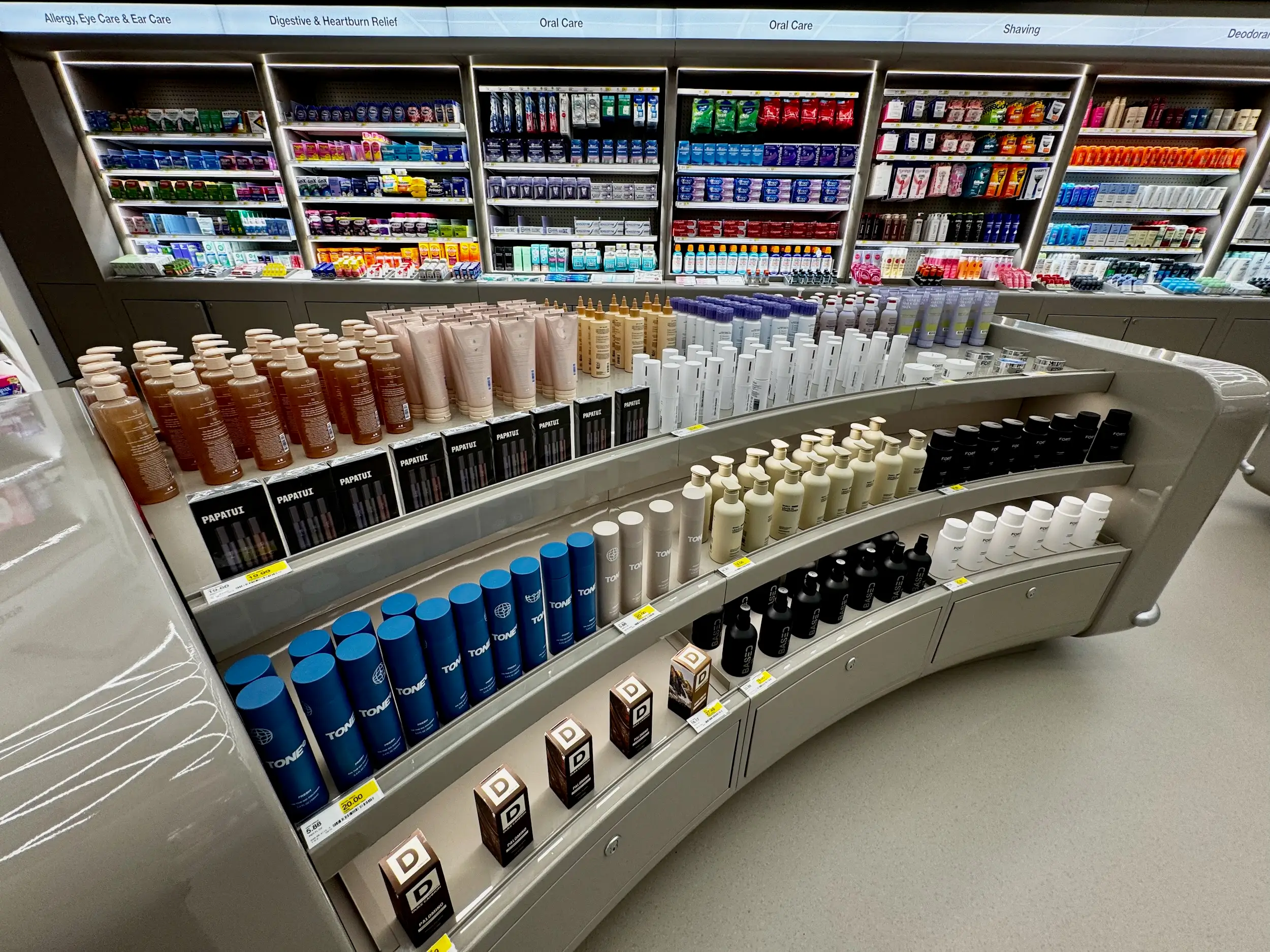Pharmacy beauty and personal care shelves display lotions, deodorants, shaving products, oral care items and medications.