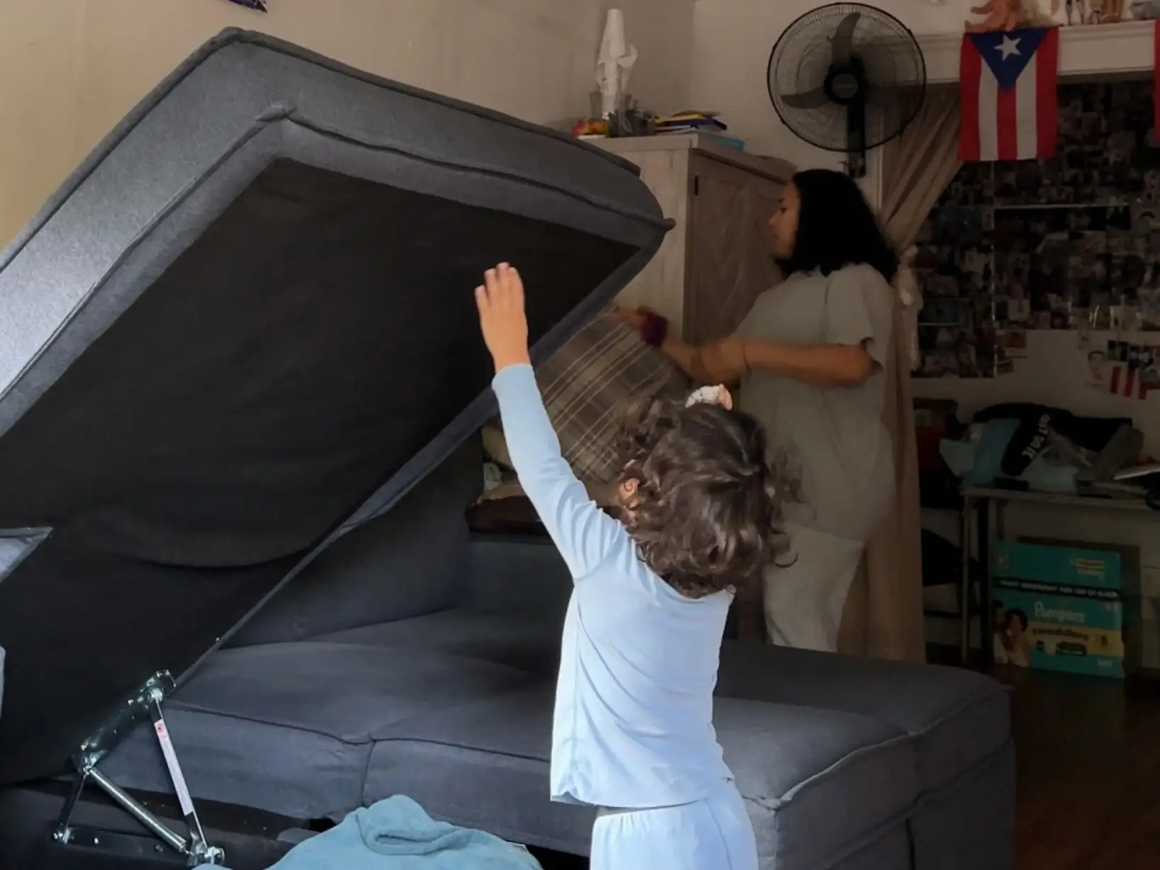 Yaritza's young son opens the sofa bed.