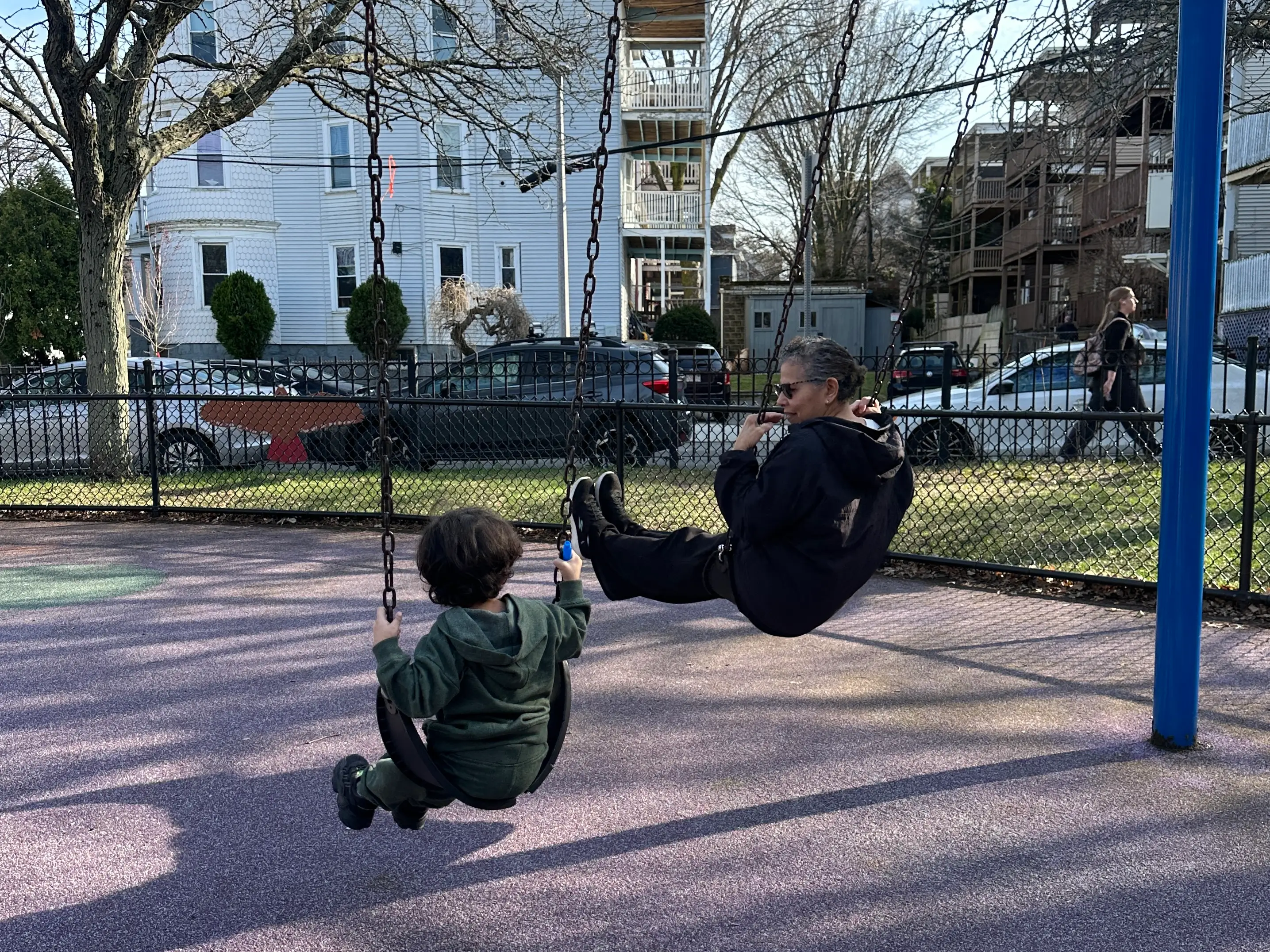 Yaritza's mother and son on a swing set.