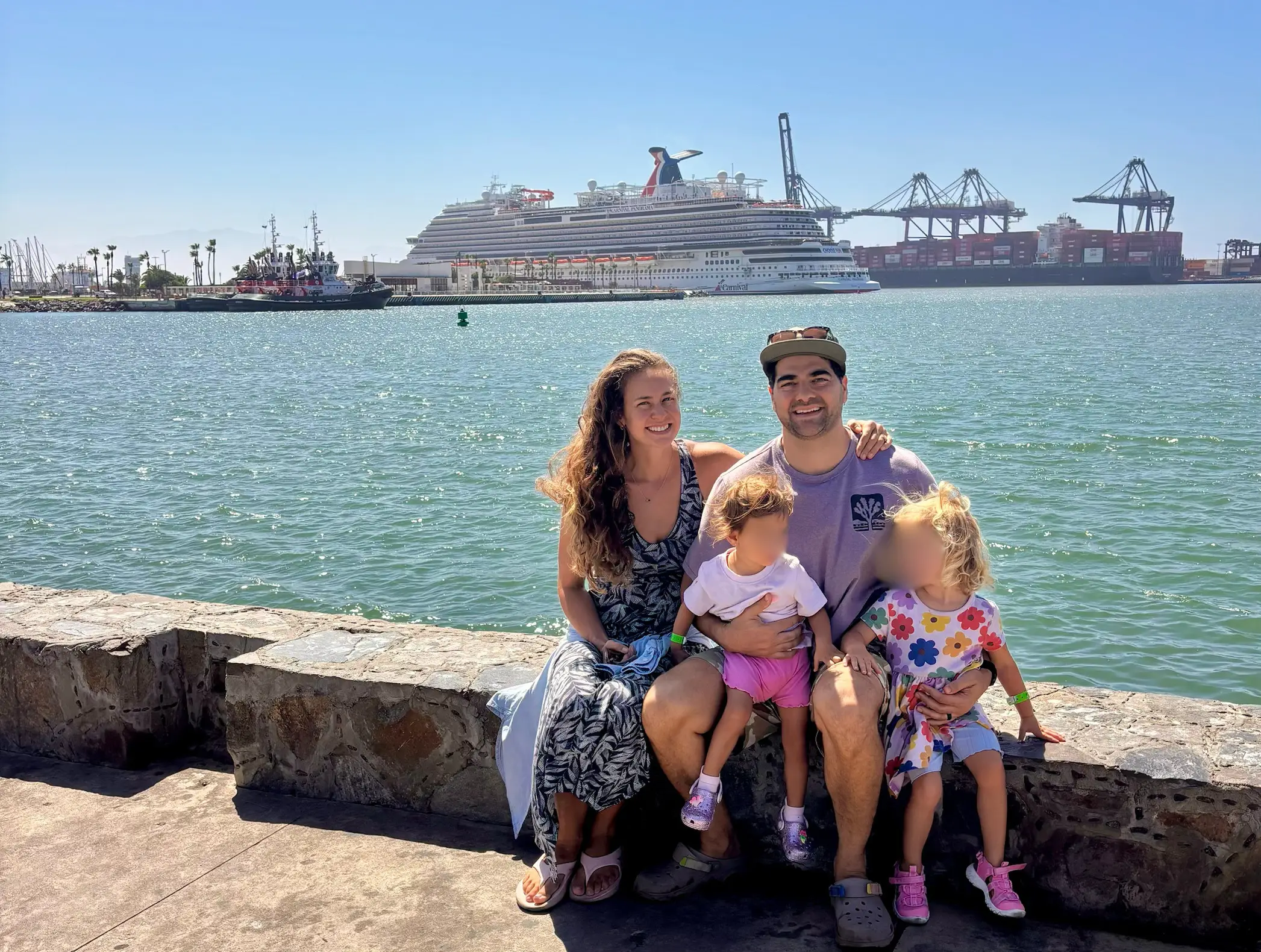 Family smiling with view of cruise ship in distance