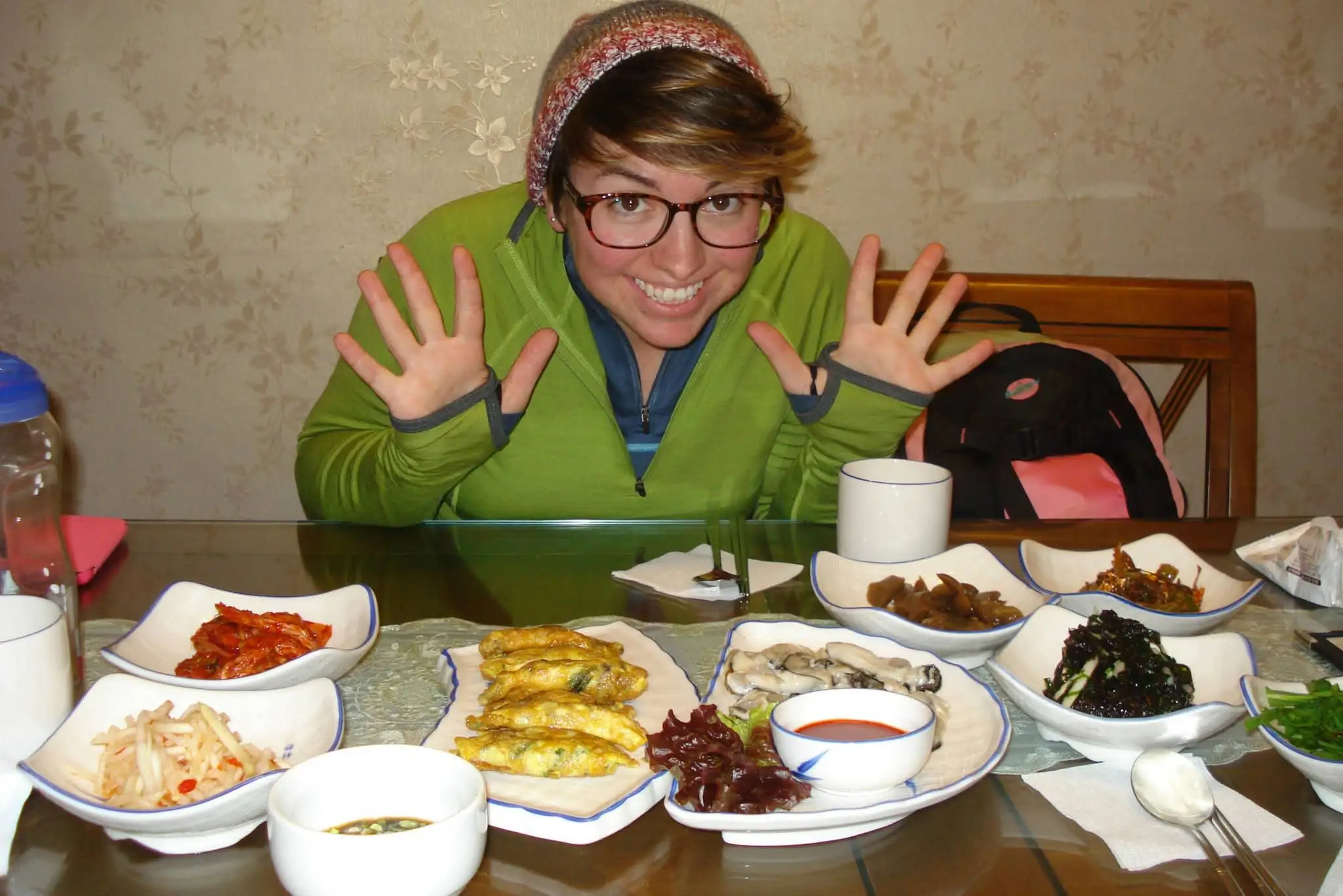 A woman at a table in South Korea with Korean dishes on the table.