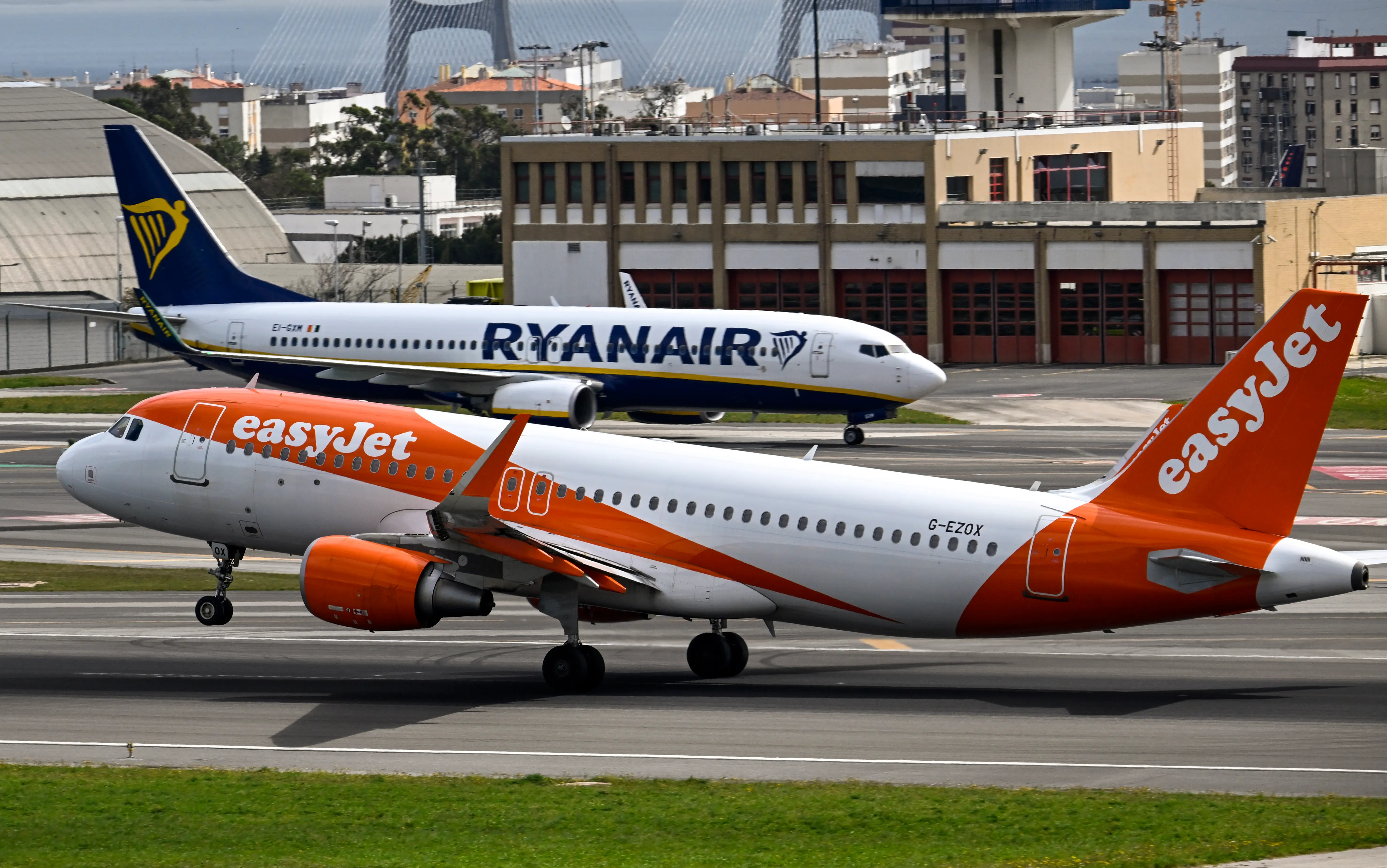 LISBON, PORTUGAL - APRIL 01: An easyJet aircraft moves past
a Ryanair airplane while taking off for London at Humberto Delgado International Airport during the first of a three-day strike by the low cost carrier cabin crew on April 01, 2023 in Lisbon, Portugal. EasyJet cabin crew strike in Portugal, called by the National Civil Aviation Flight Personnel Union (SNPVAC), takes place from April 01 to 03. The Portuguese Ministry of Infrastructure and the Ministry of Labor ordered that there have be a minimum service of 52 easyJet flights during the workers' strike, deemed necessary to meet social needs relating to the constitutional right to travel, taking into account the season covered by the declared strike days, on which is expected the displacement of a significant number of people. (Photo by Horacio Villalobos#Corbis/Getty Images)