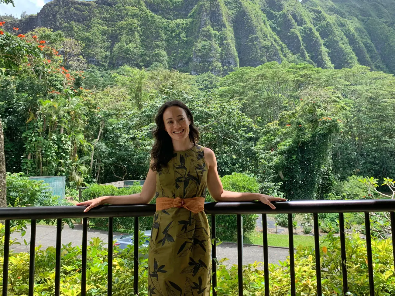Jana stands in front of lush, green vegetation.