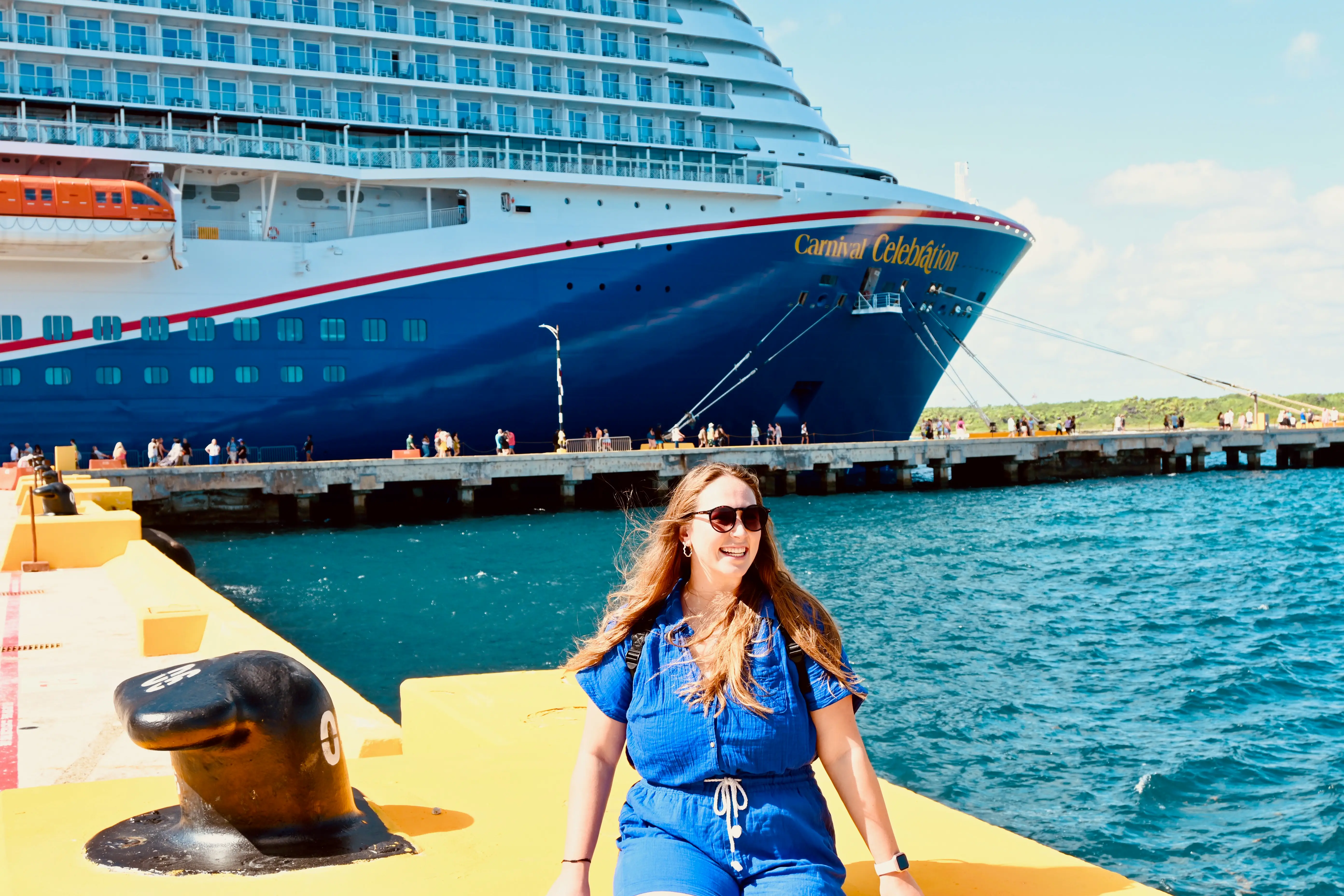 Woman smiling with Carnival Celebration cruise ship behind her