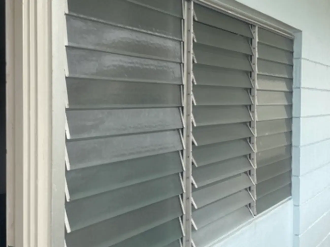 A jalousie window with horizontal glass slats.