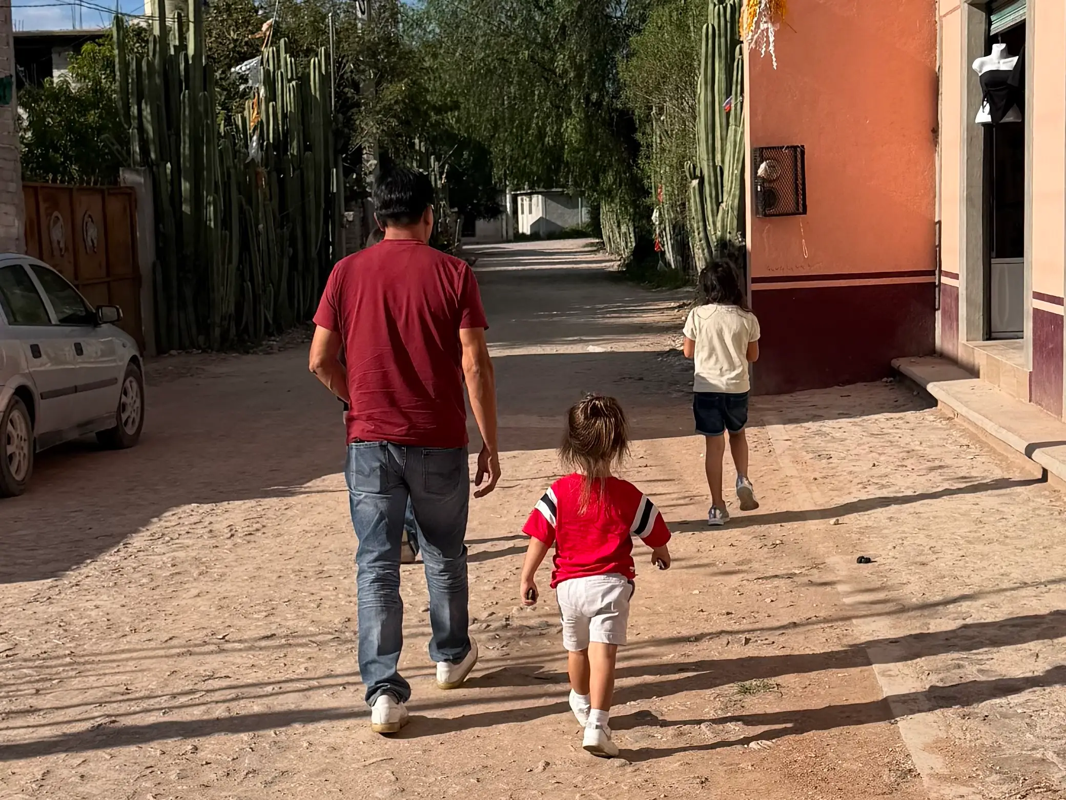 Adult walking on cobblestones with two children
