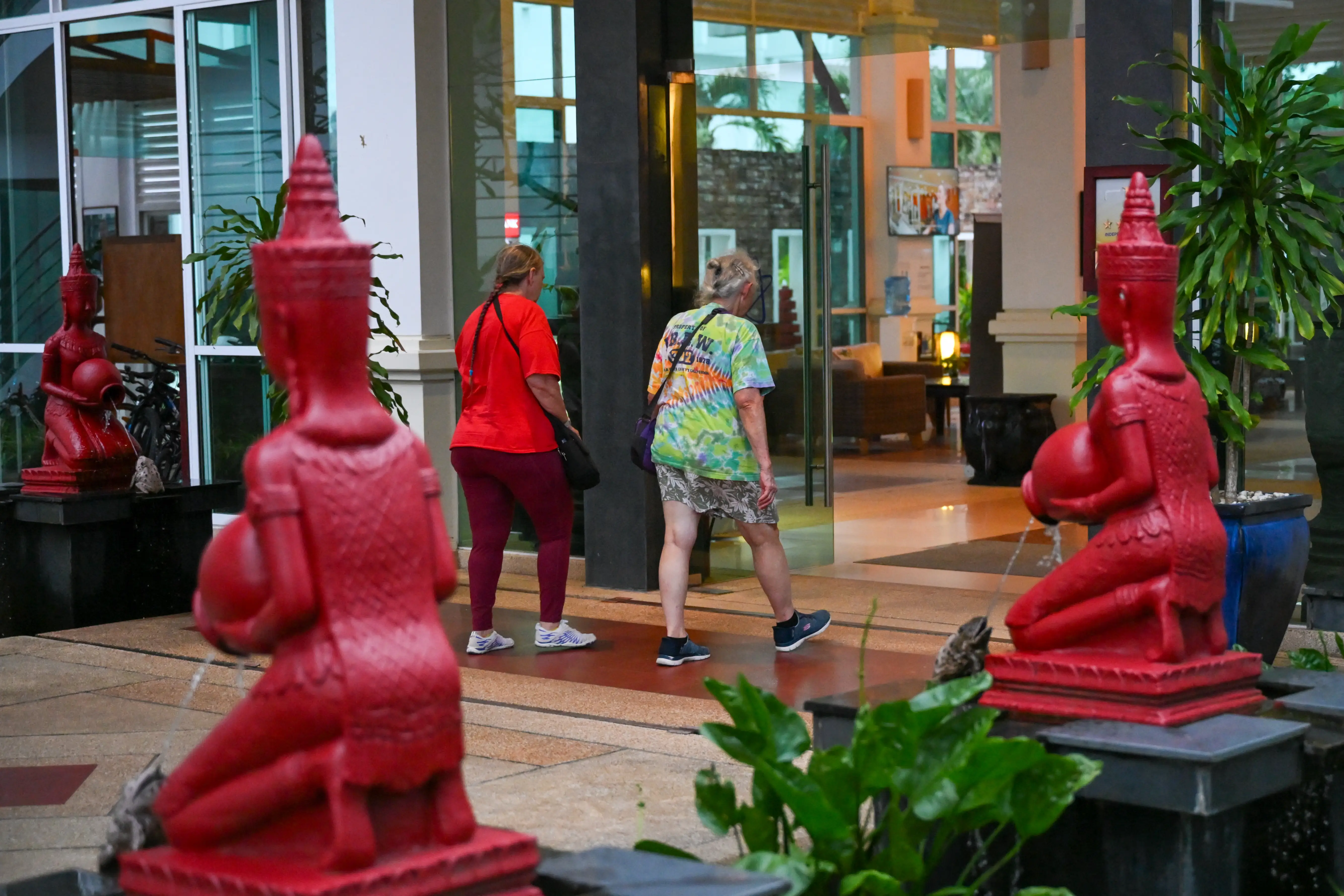 Two people approach the front doors of a hotel in Sihanoukville, Cambodia.