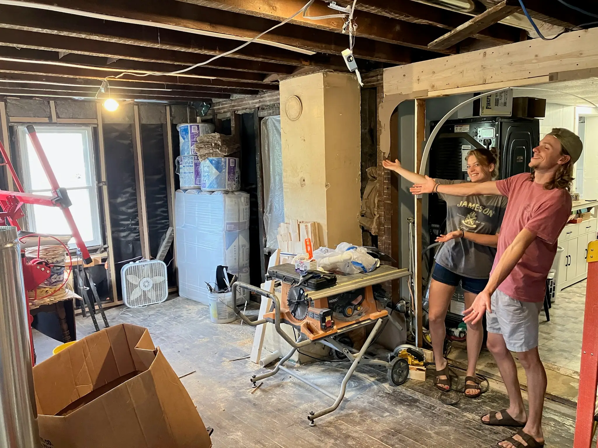 The writer and her husband are standing in their home while it is undergoing a renovation.