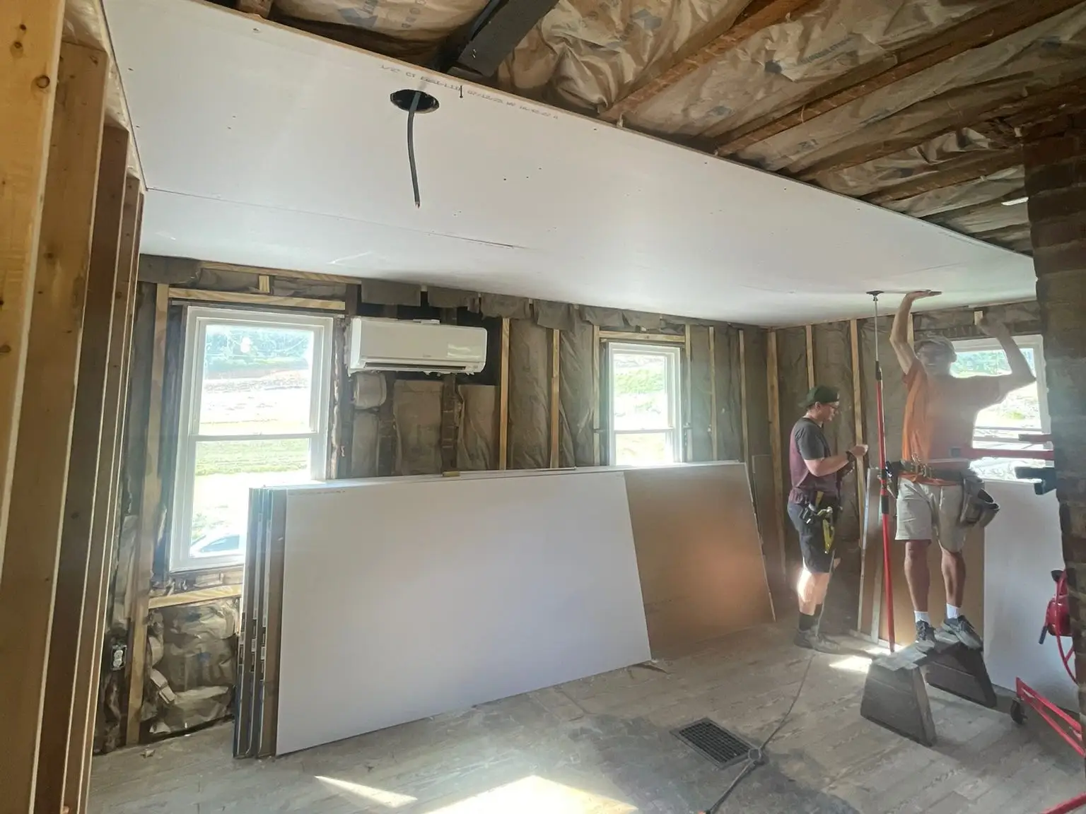 Friends and family of the writer help install drywall in their home.