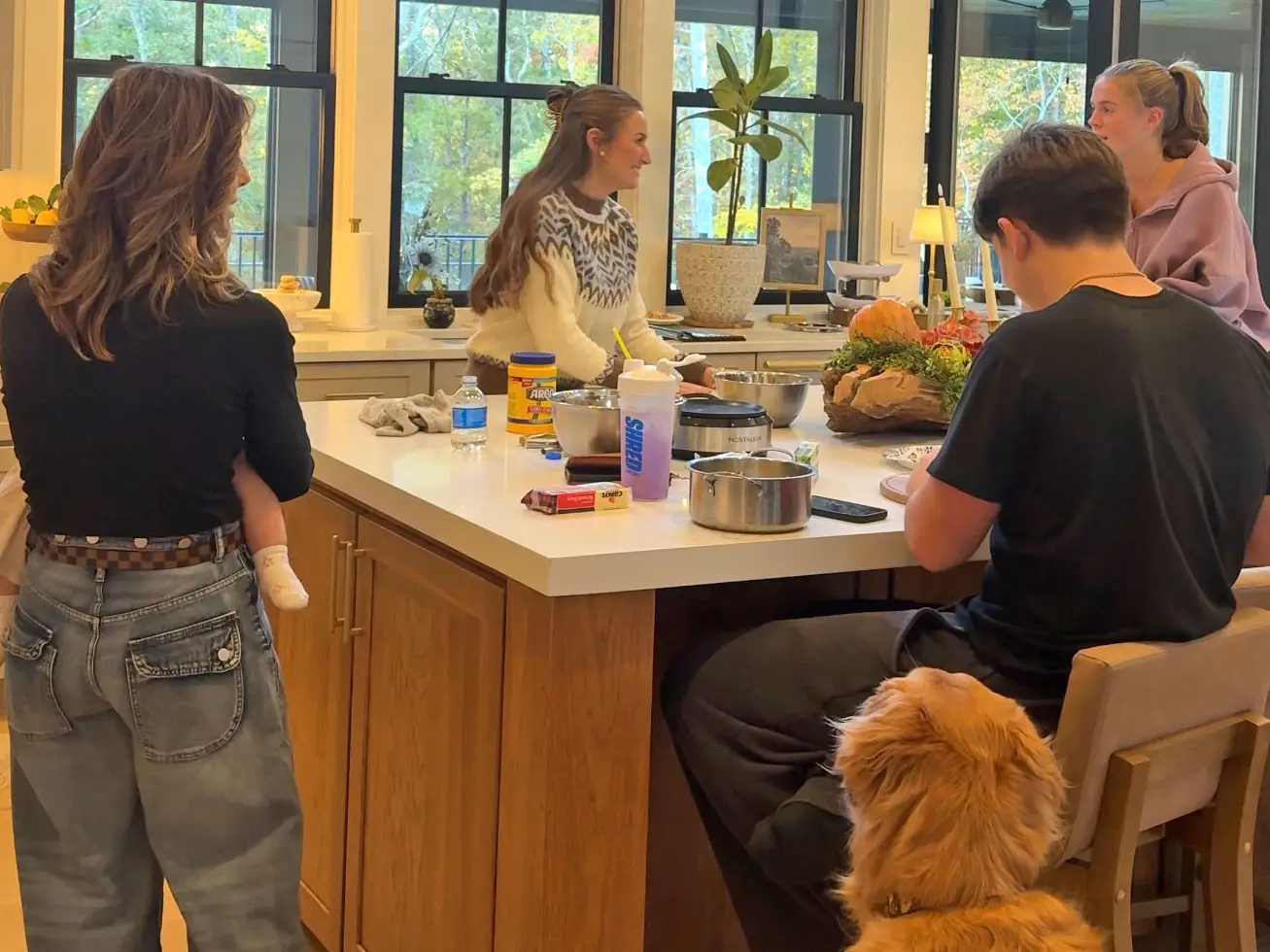 Taylor and her family stand around a kitchen island.