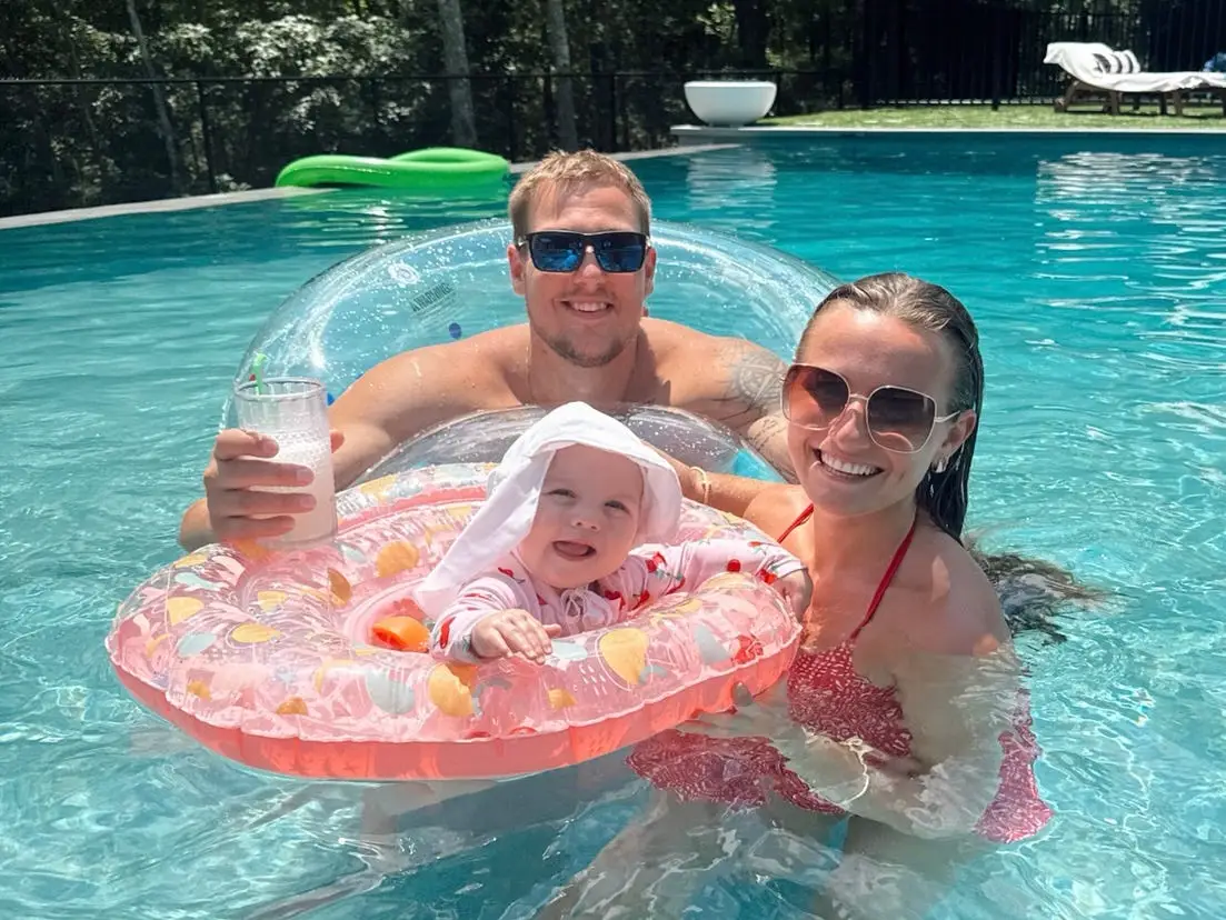 Taylor, her husband, and their daughter in the pool.