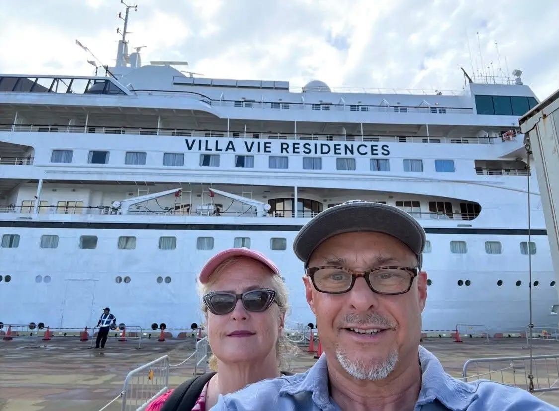 A couple taking a selfie with the ship.