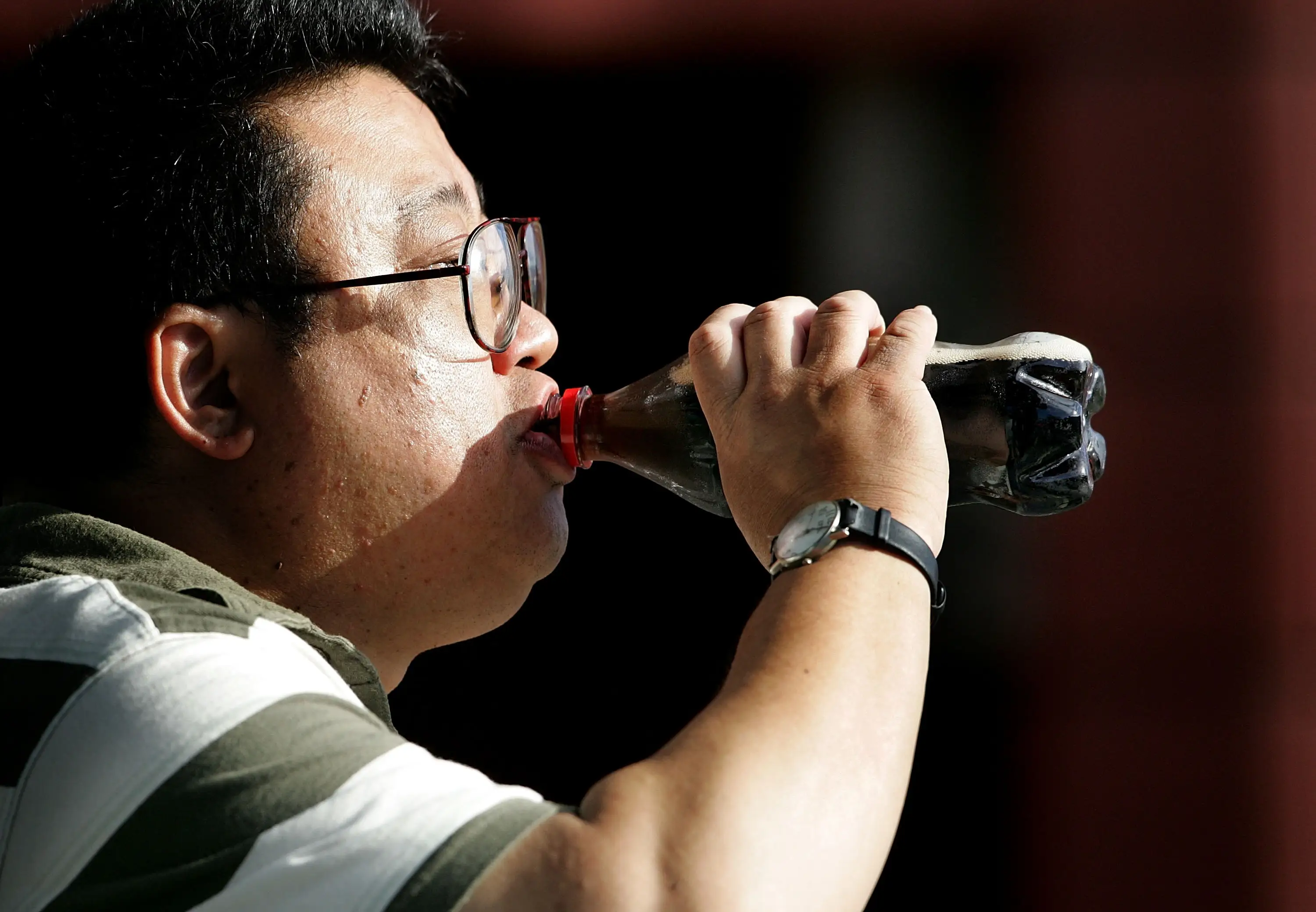 A man drinks a bottle of Diet Coke