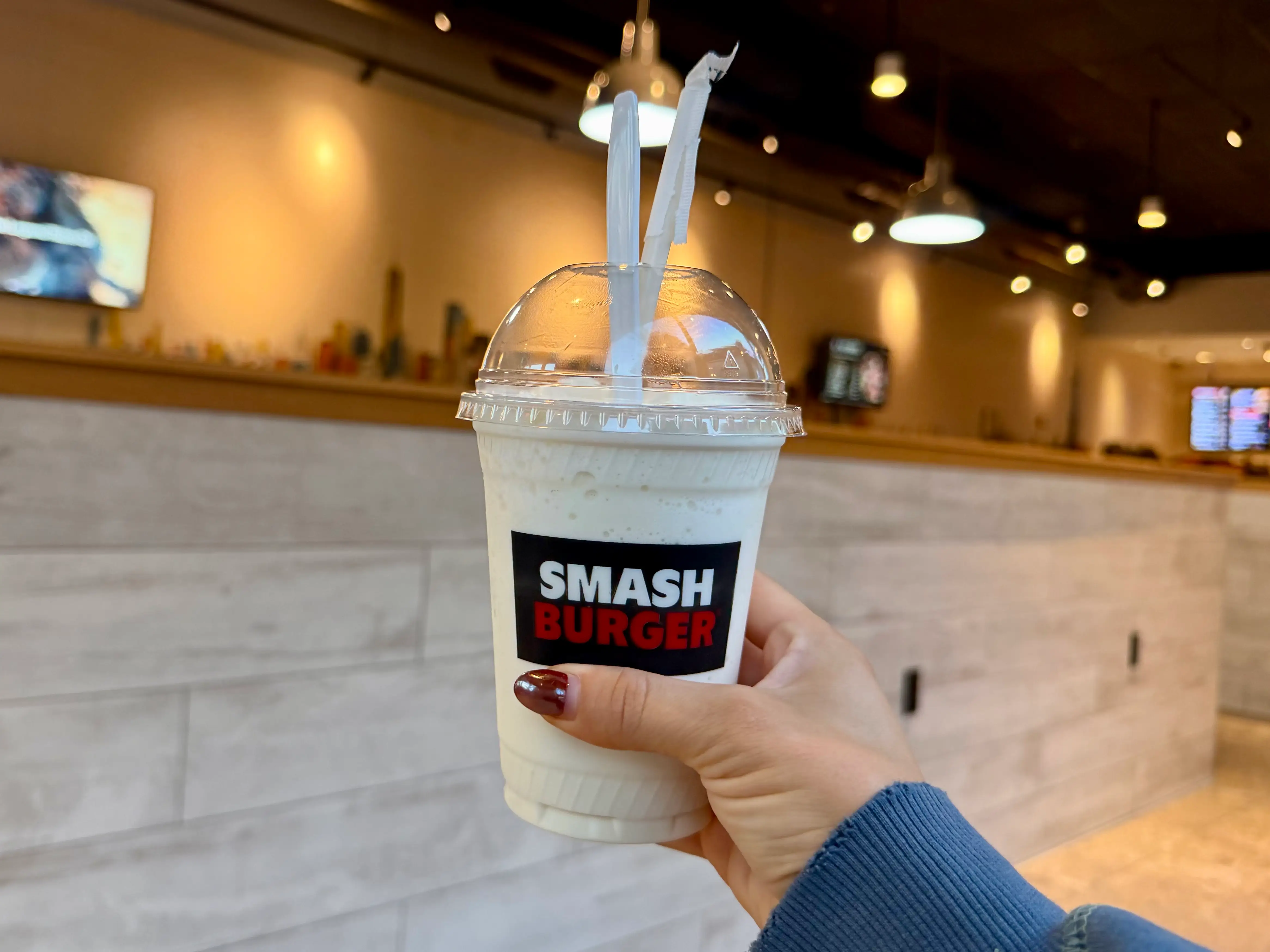 Amanda holds a vanilla milkshake from Smashburger.