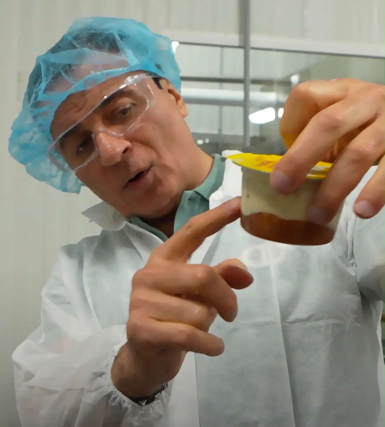 Charles Hanna wears protective equipment as he points to a product