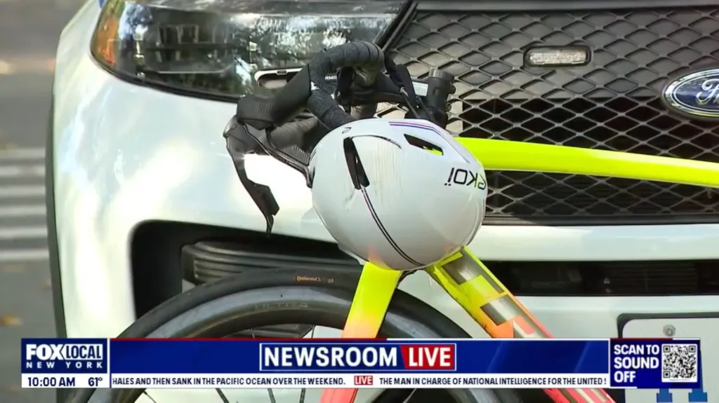A bicycle and helmet parked in front of a police vehicle.