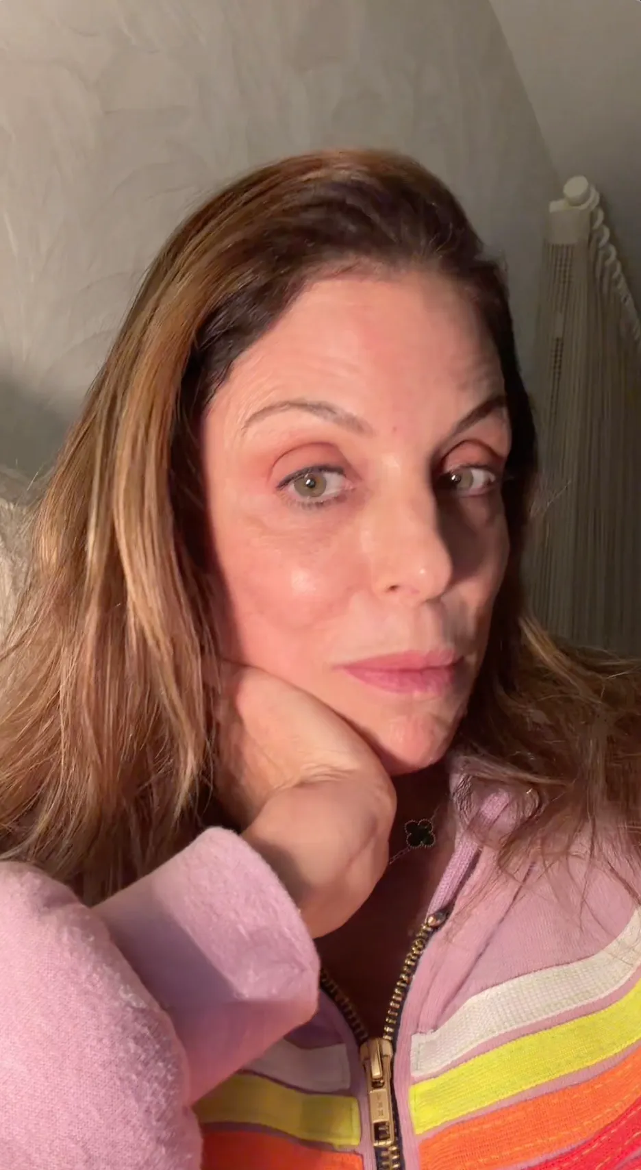 Bethenny Frankel rests her chin in her hand, looking seriously at the camera.