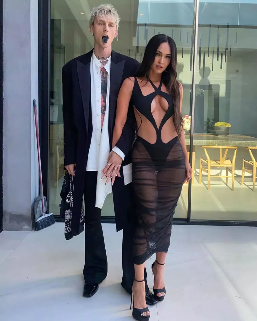 Machine Gun Kelly and Megan Fox posing together outside.