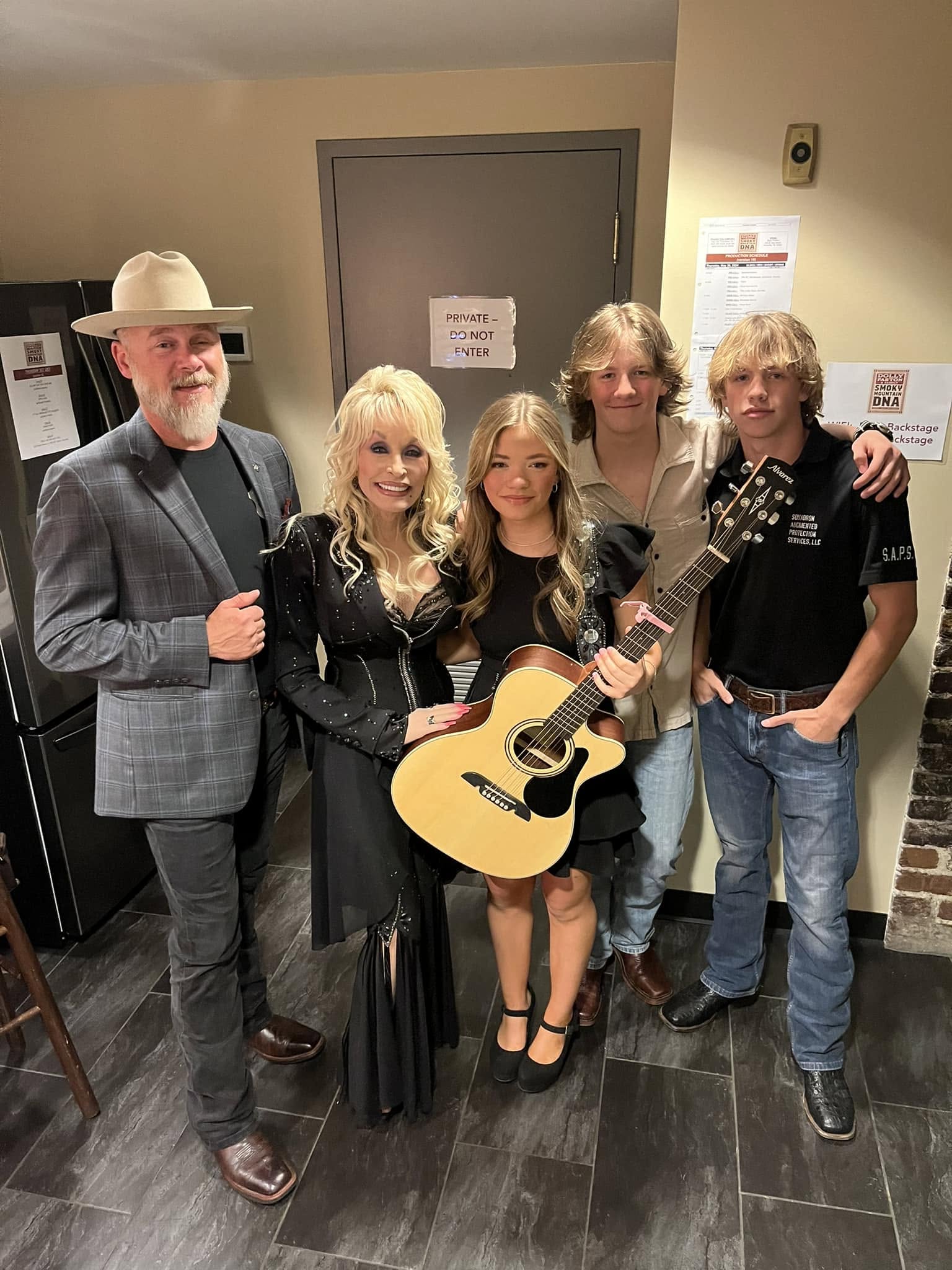 Dolly Parton poses indoors with Bryan Seaver and his family.