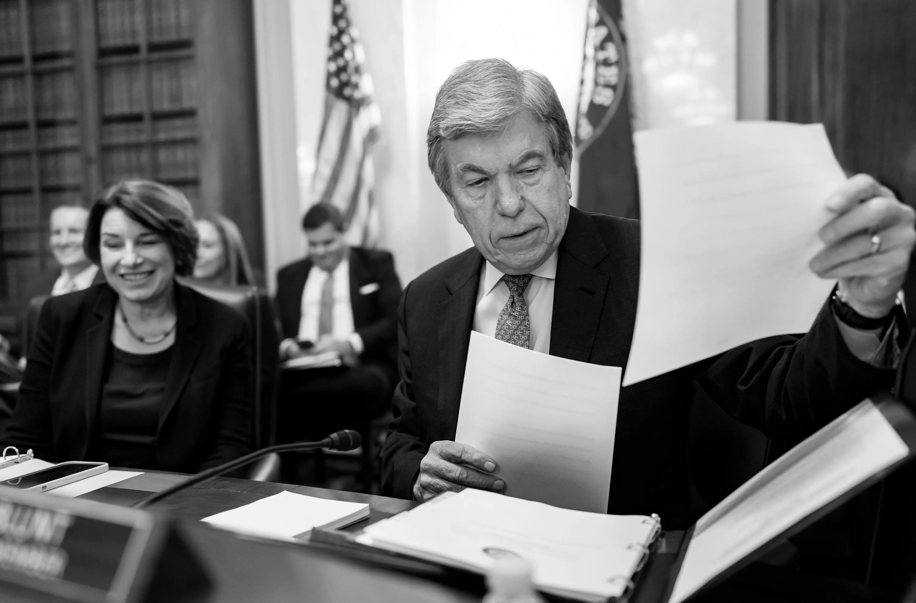 Amy Klobuchar and Roy Blunt look through documents