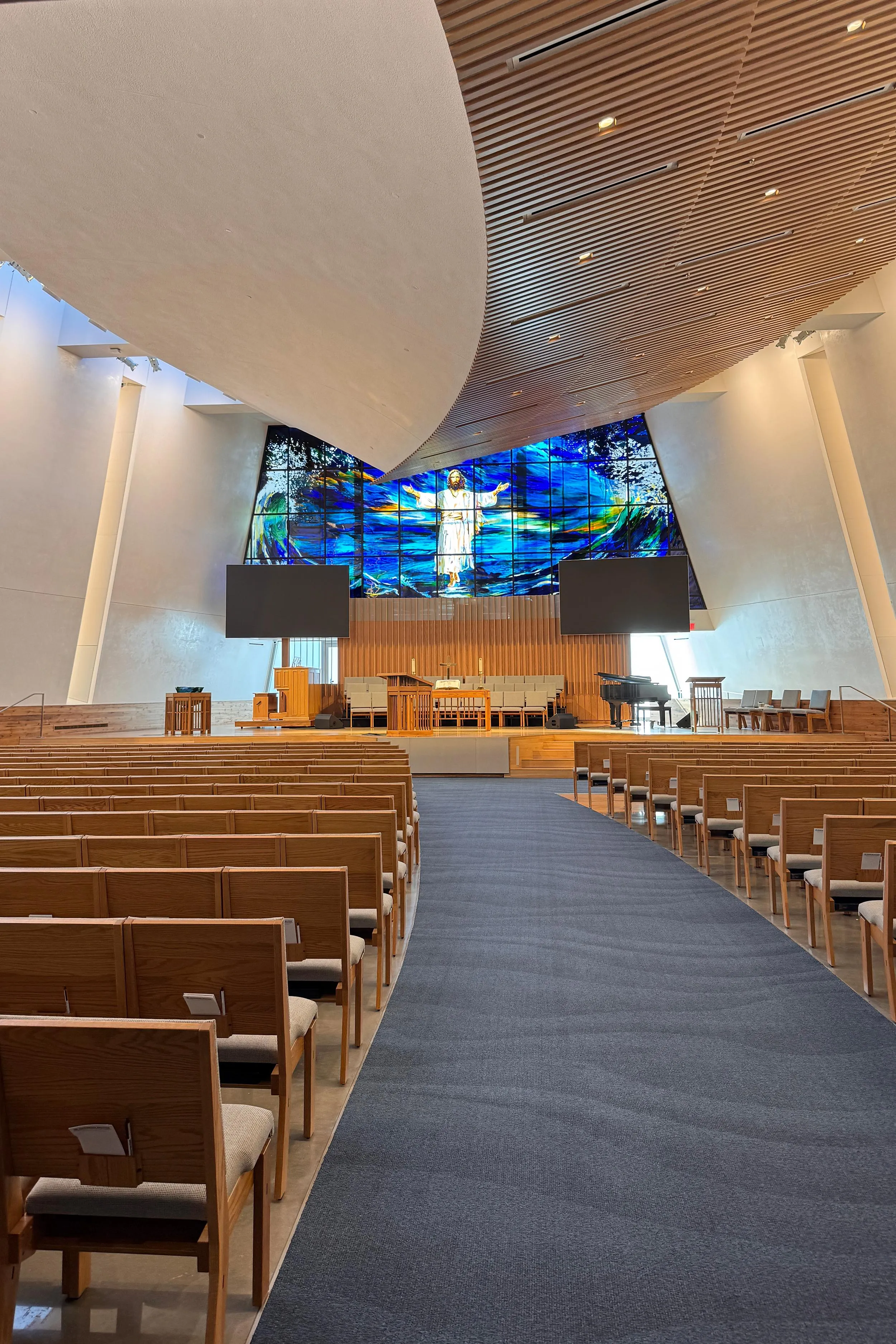an empty church interior with bright stained glass windows and an architectural ceiling that looks like the bottom of a boat an empty church interior with bright stained glass windows and an architectural ceiling that looks like the bottom of a boat