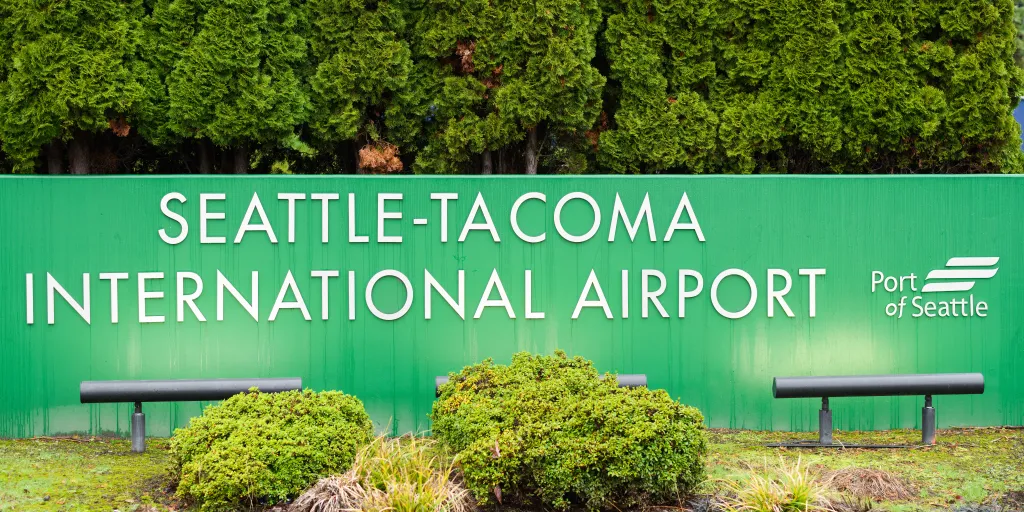 Green sign with white text that reads Seattle-Tacoma International Airport.