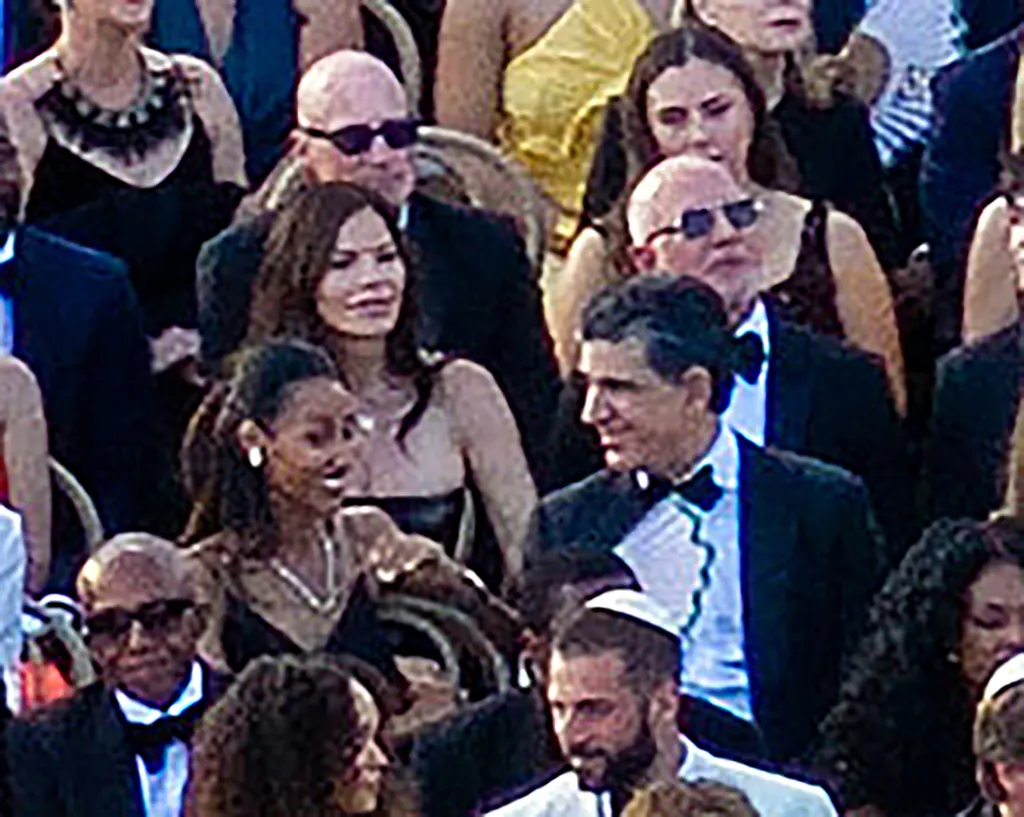 A crowd of people, many wearing formal attire, seated at an event.