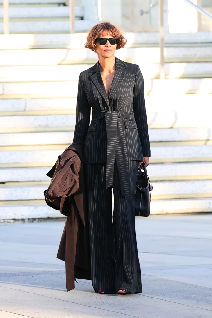 Halle Berry arriving at court in a black pinstripe suit and sunglasses.