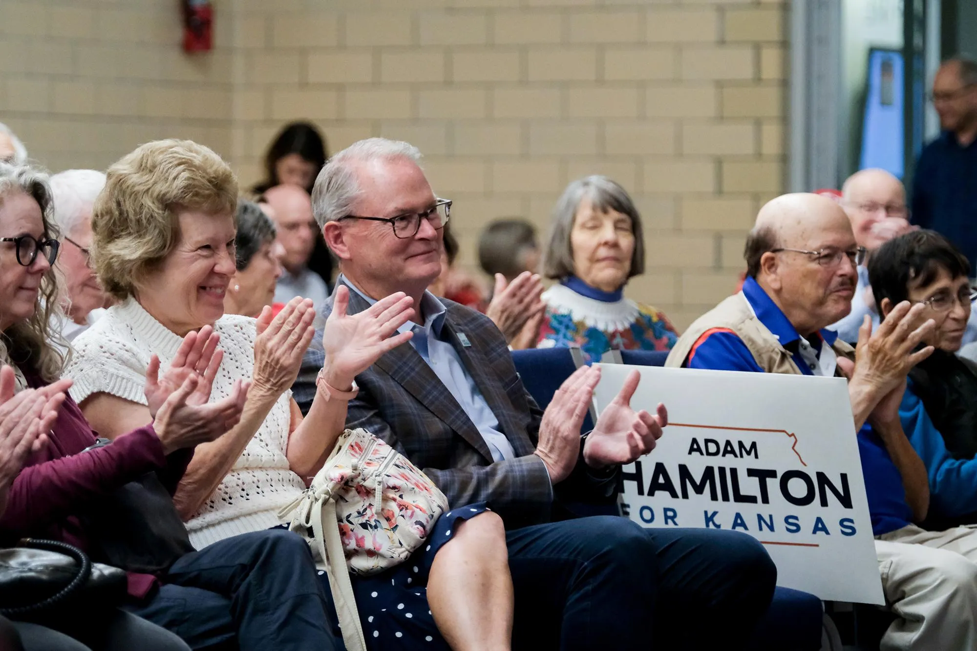 Adam Hamilton sitting in a crowd of supporters who are clapping Adam Hamilton sitting in a crowd of supporters who are clapping